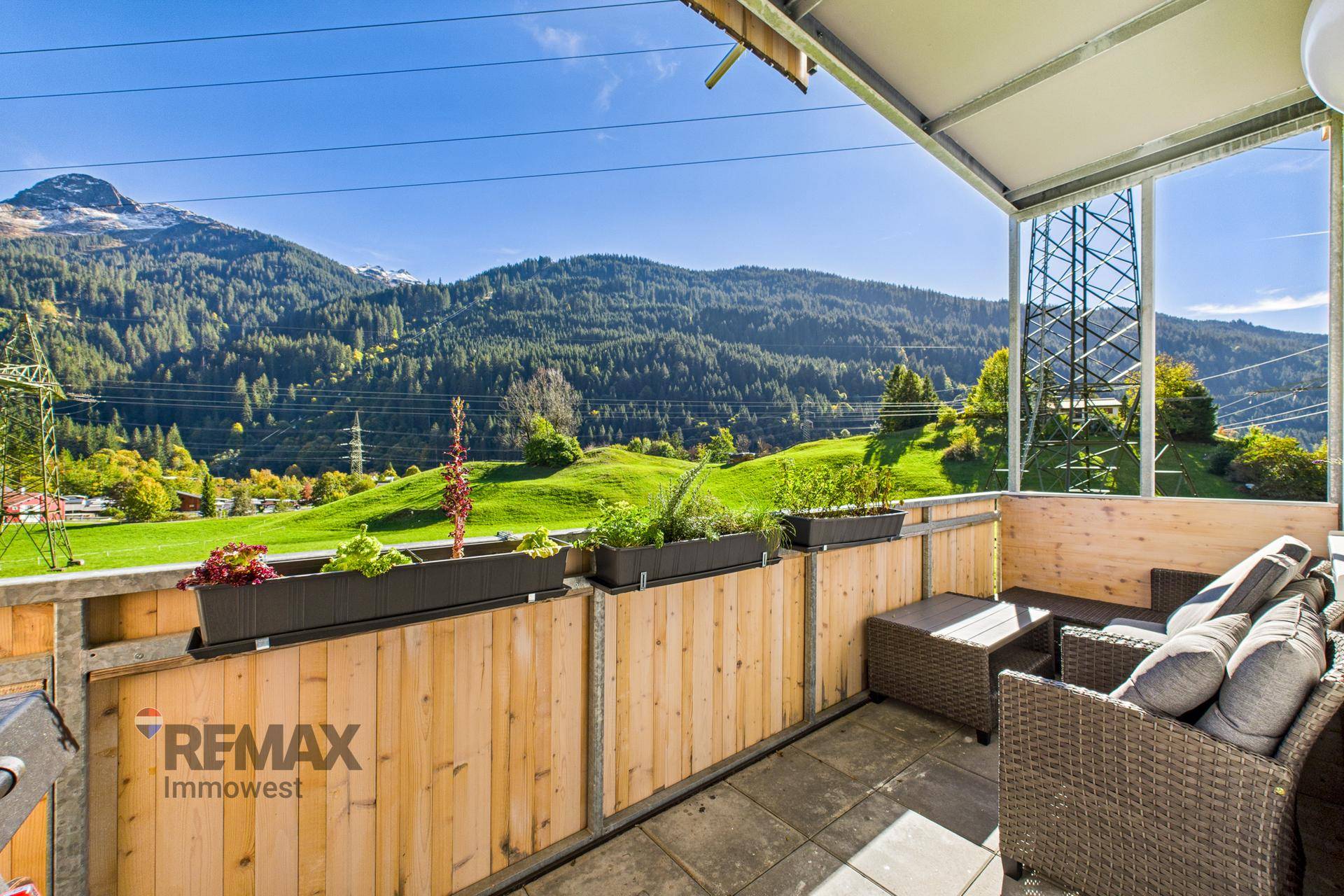 Geräumiger Balkon mit bequemen Outdoor-Möbeln und weitem Blick auf die grüne Bergwelt.