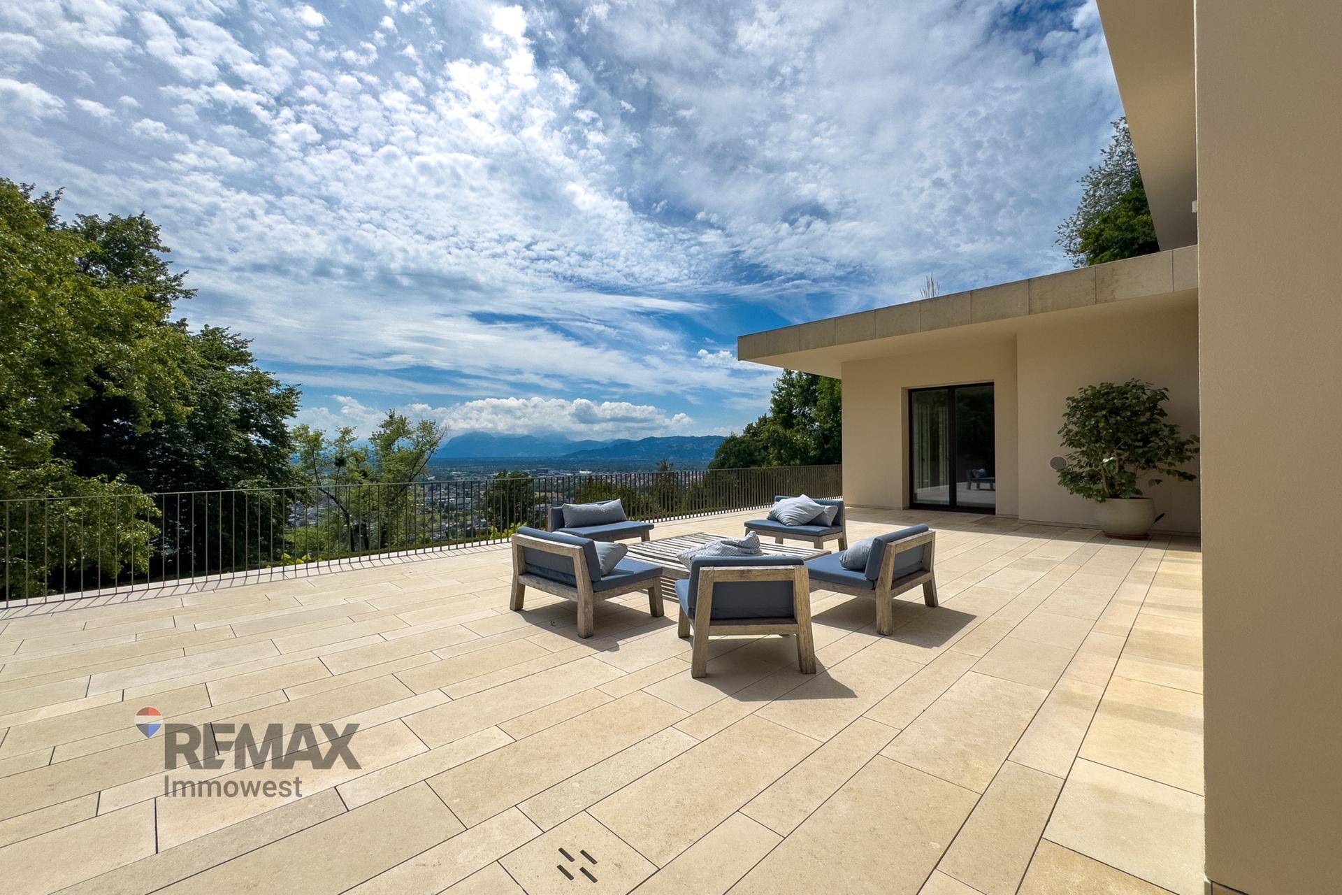 Weitläufige Terrasse mit bequemen Loungemöbeln und Panoramablick auf die Stadt und die umliegende Landschaft.