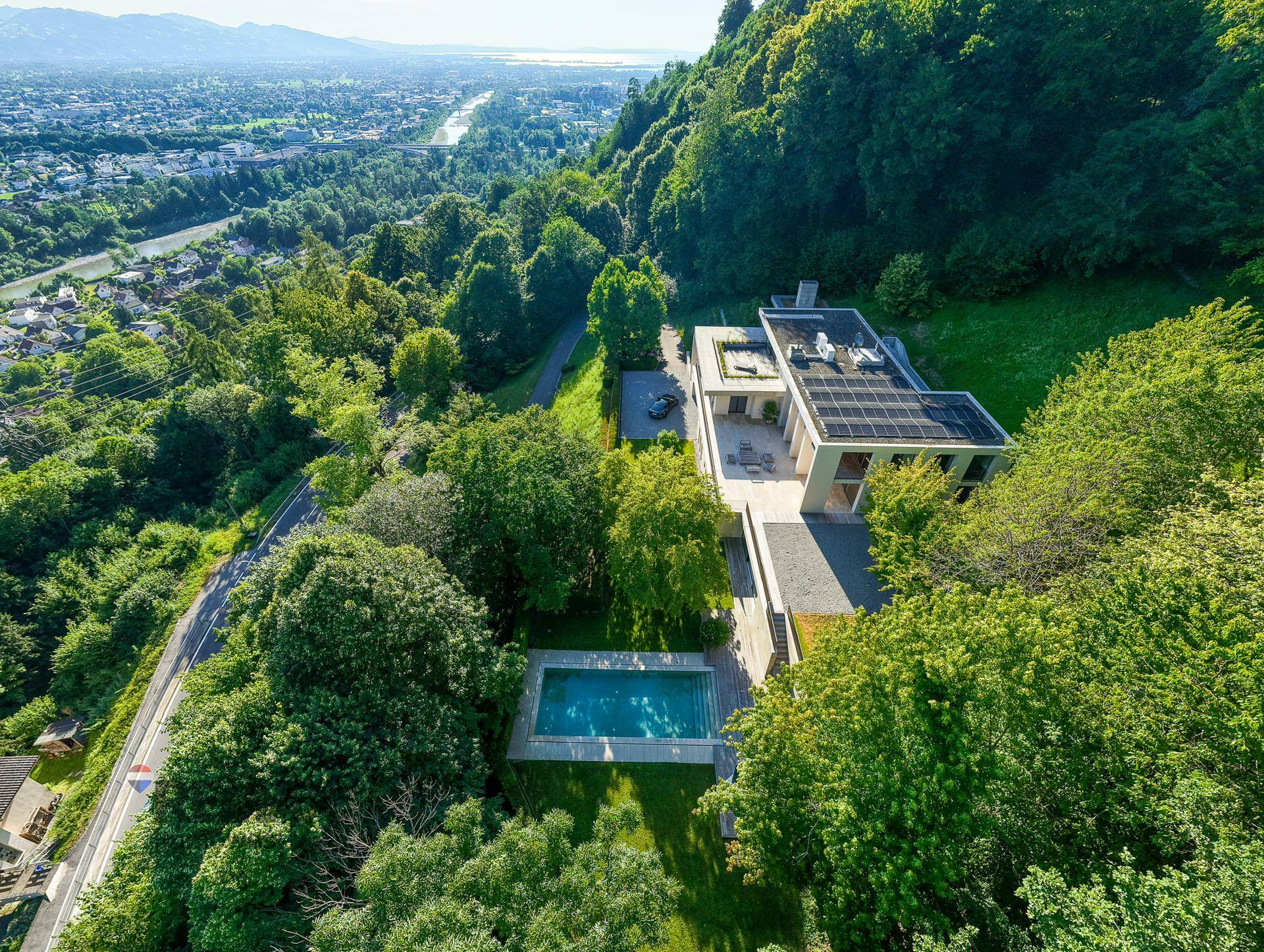 Panoramablick aus der Vogelperspektive auf die Villa mit großem Pool und der umliegenden grünen Landschaft.