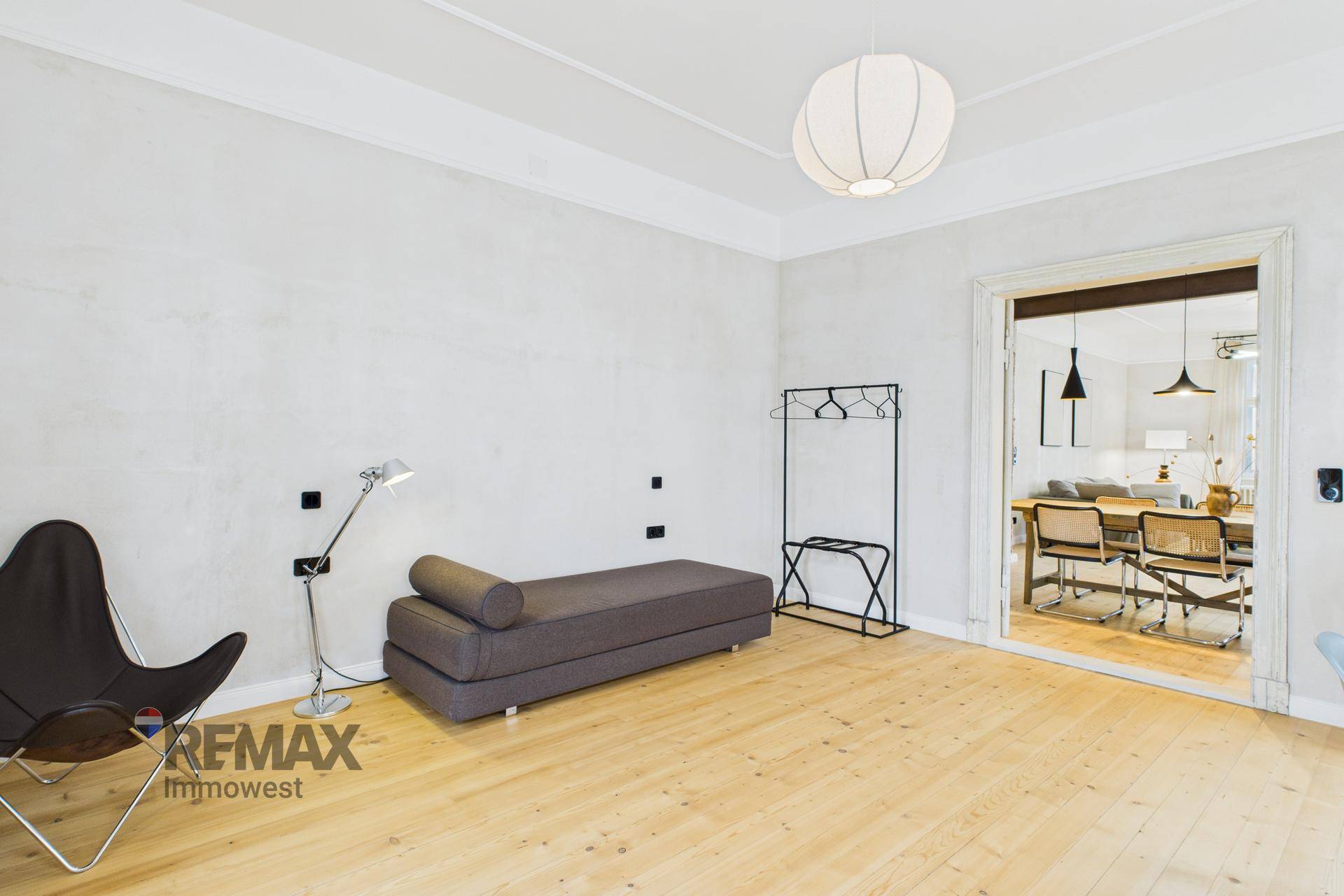 Heller Flur mit Tagesliege und Zugang zu weiteren Räumen der Wohnung.