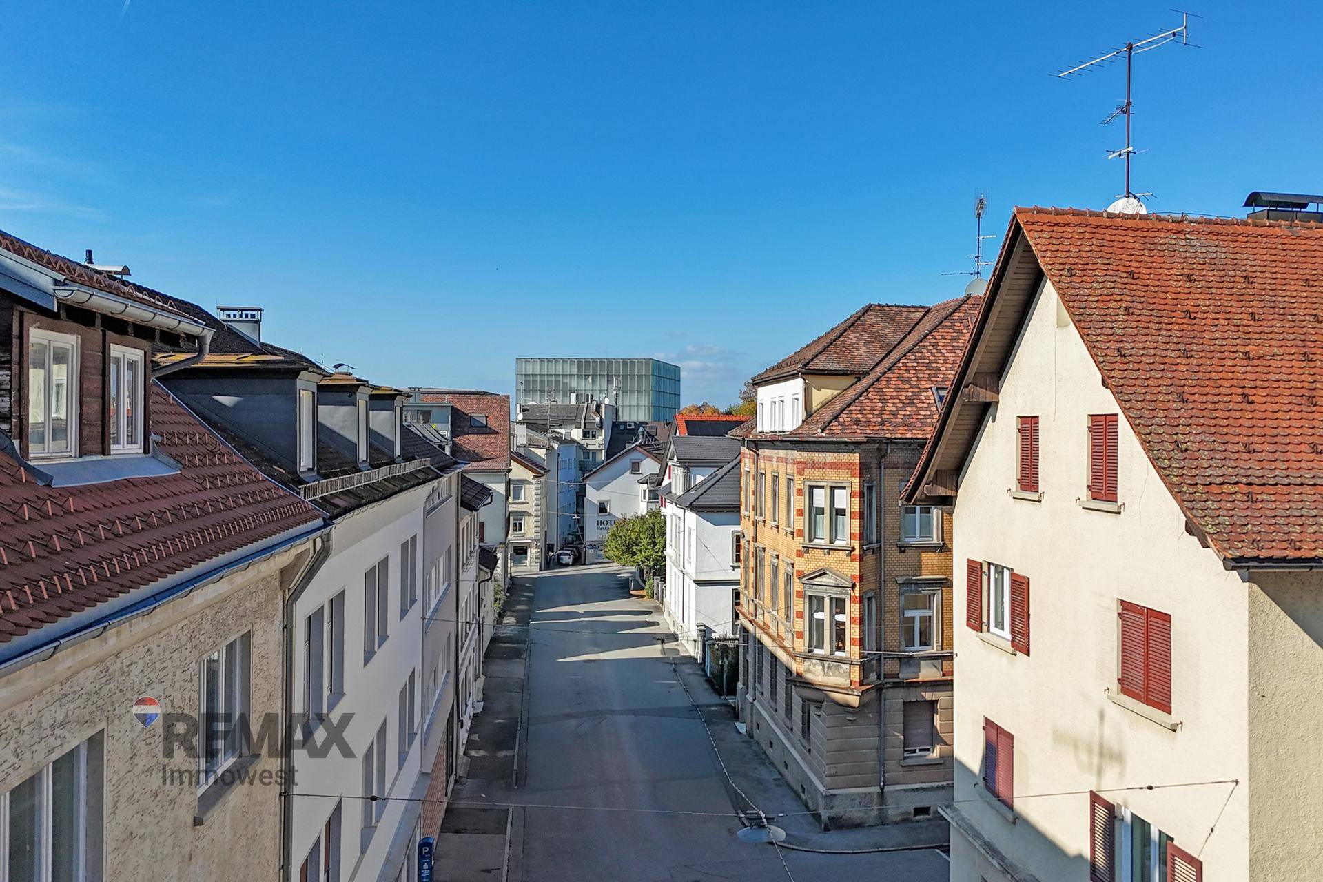 Blick auf die Wohnstraße mit historischen Gebäuden und moderner Architektur im Hintergrund.