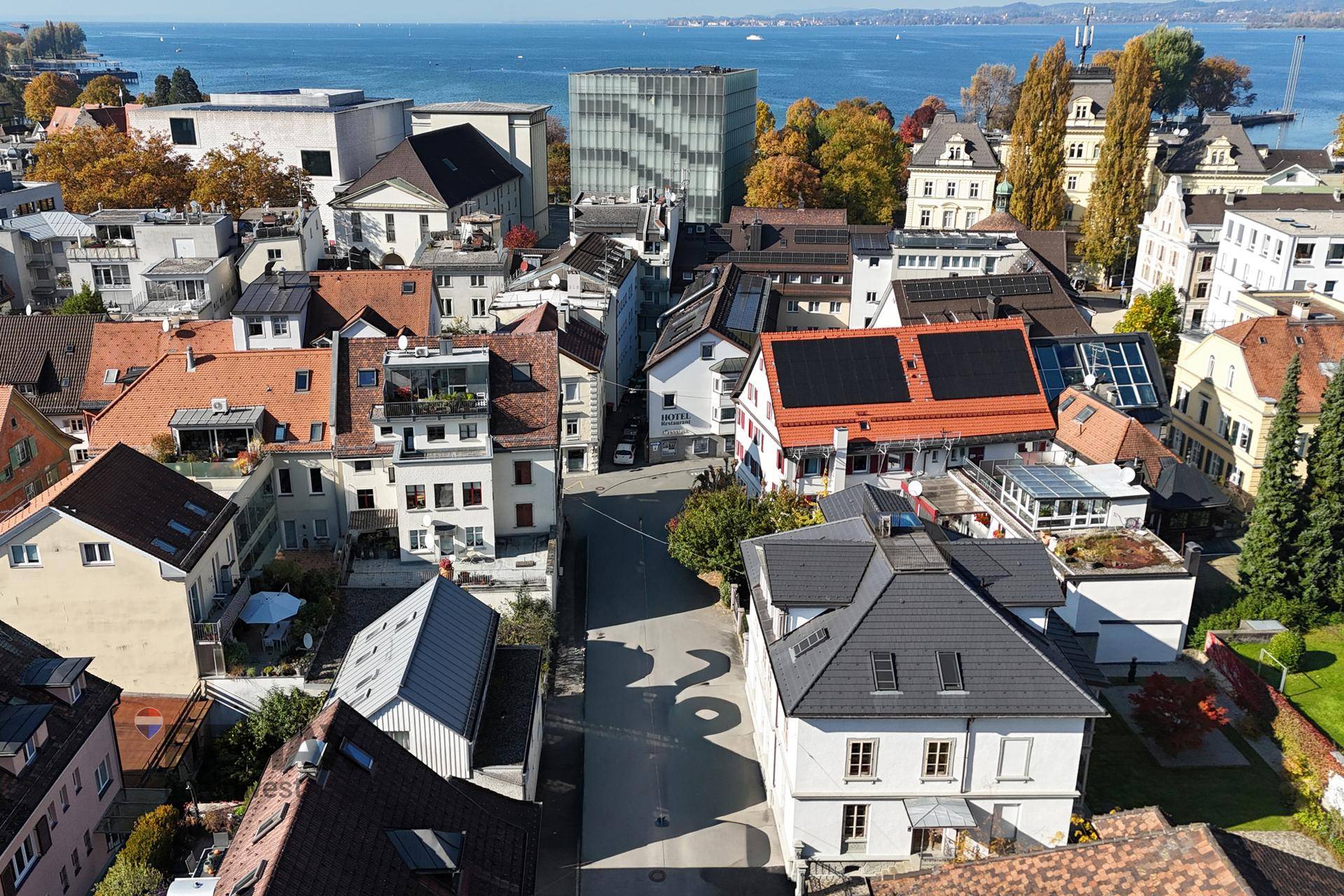 Panoramablick über die Stadt mit See und vielfältiger Bebauung unter blauem Himmel.