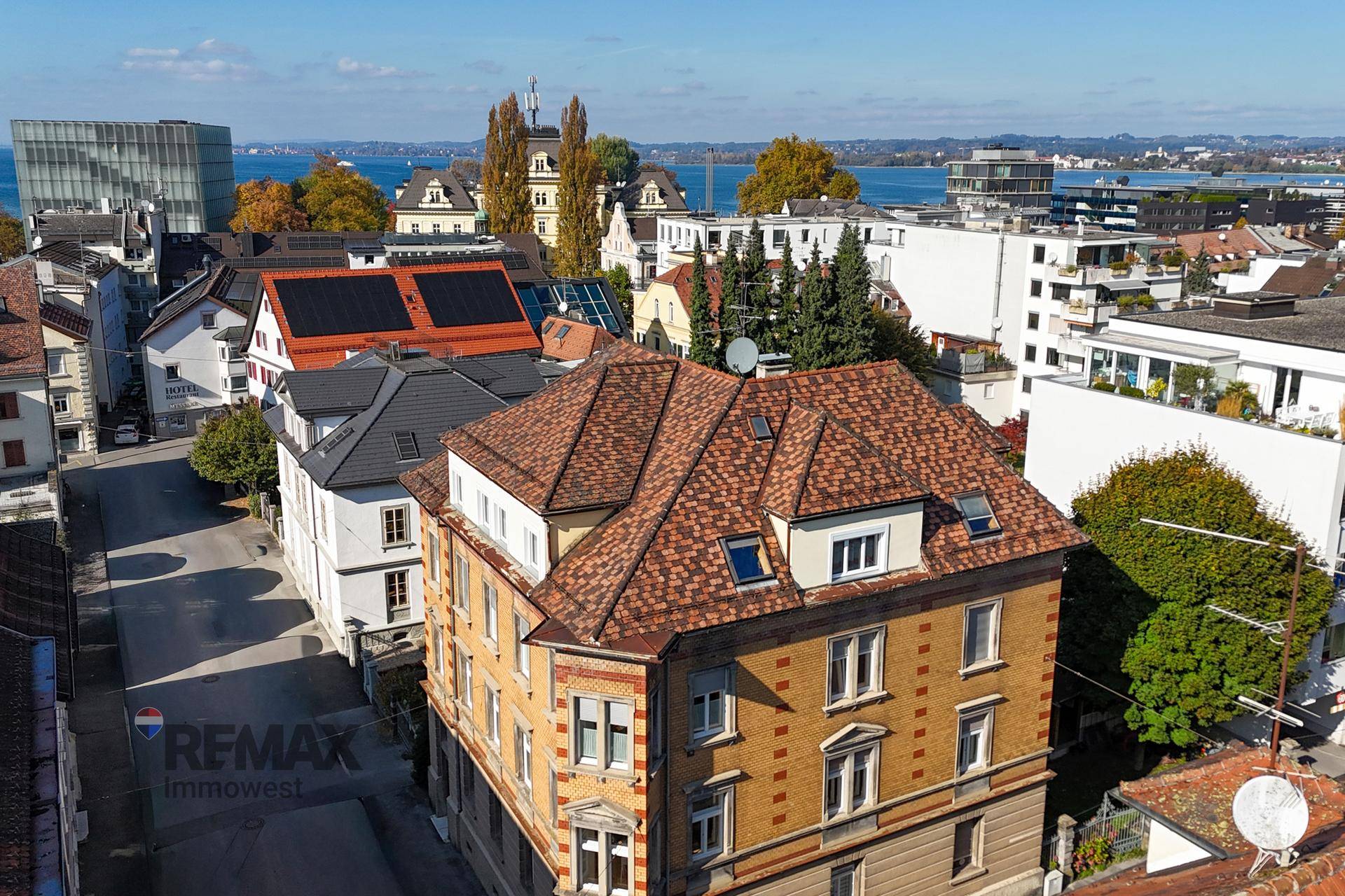 Weitläufige Luftaufnahme der Stadt mit See im Hintergrund und historischen Gebäuden.