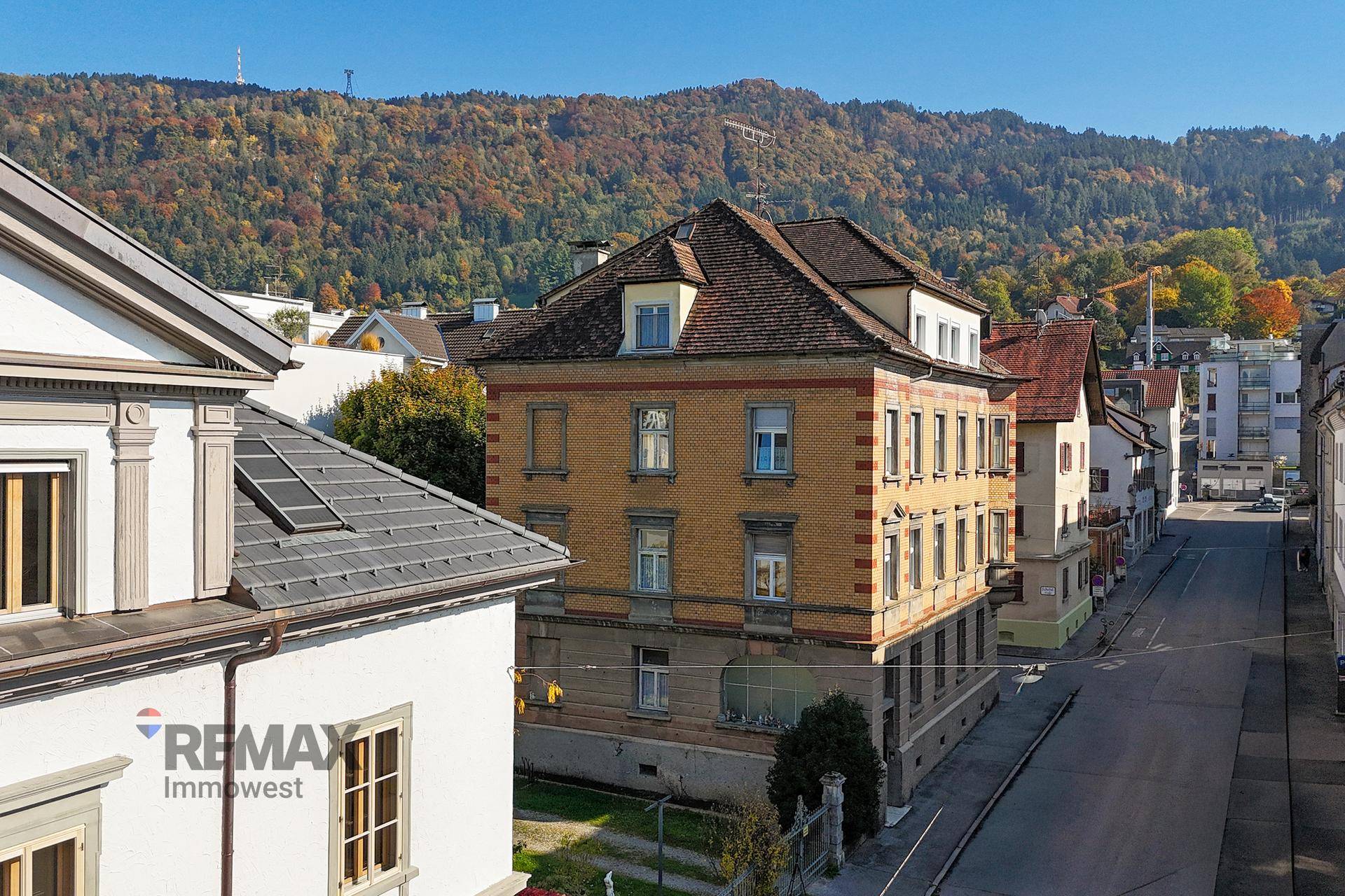 Gebäudeansicht mit Blick auf die umliegenden Berge und herbstliche Baumlandschaft.