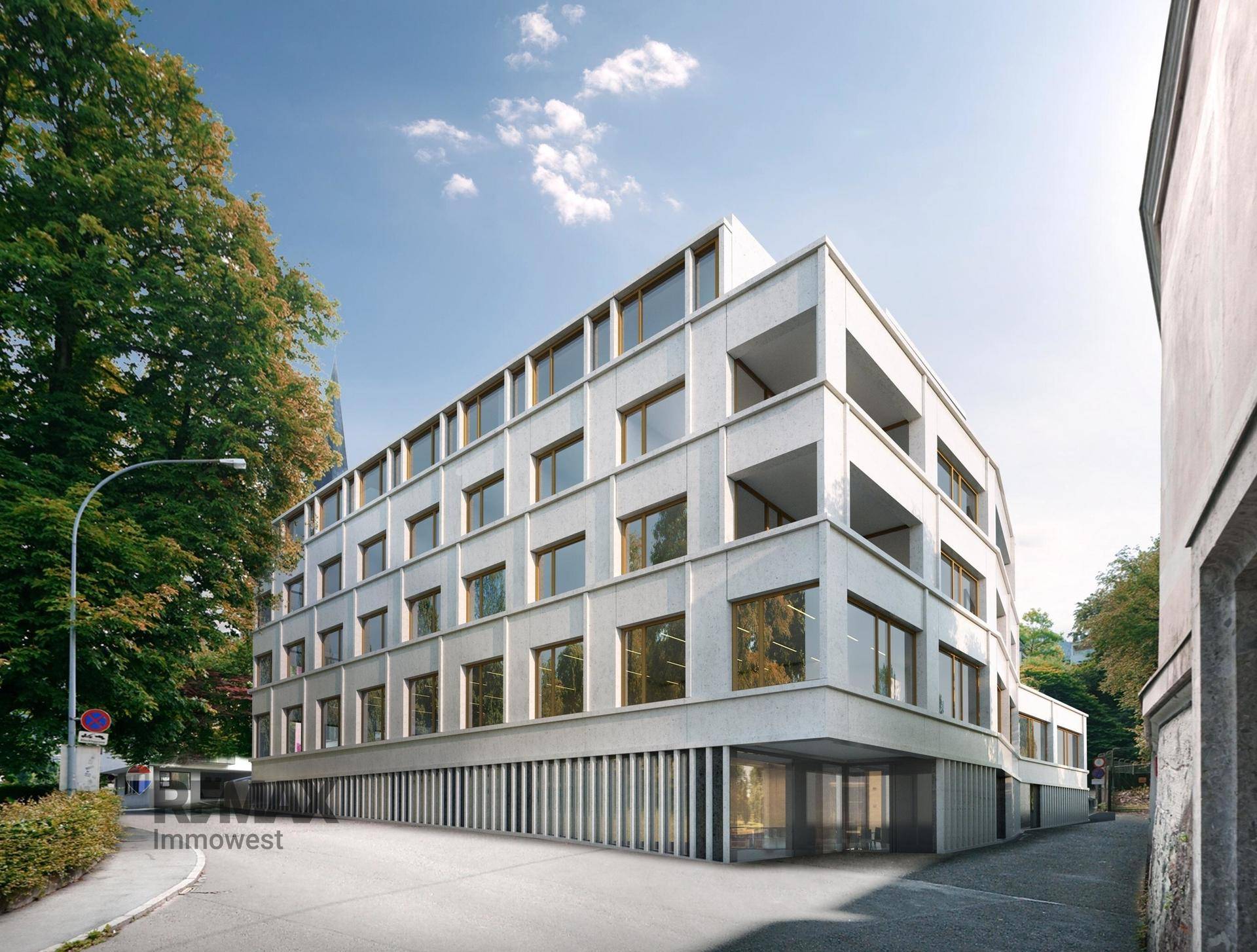 Moderne Architektur eines Mehrfamilienhauses mit klaren Linien und großen Fenstern.