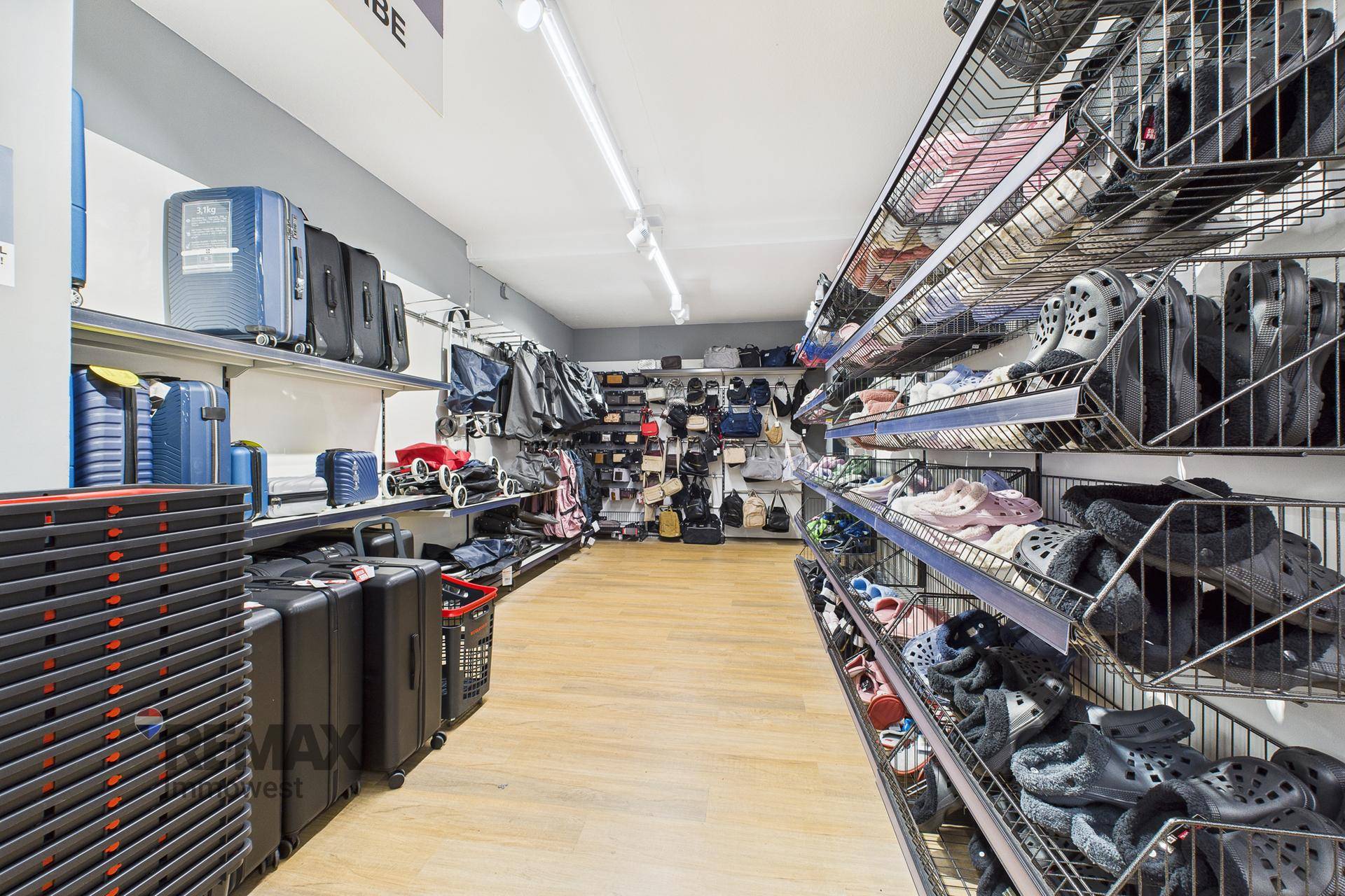 Verkaufsraum mit Regalen, die Reisegepäck und Schuhe in einer übersichtlichen Anordnung zeigen.