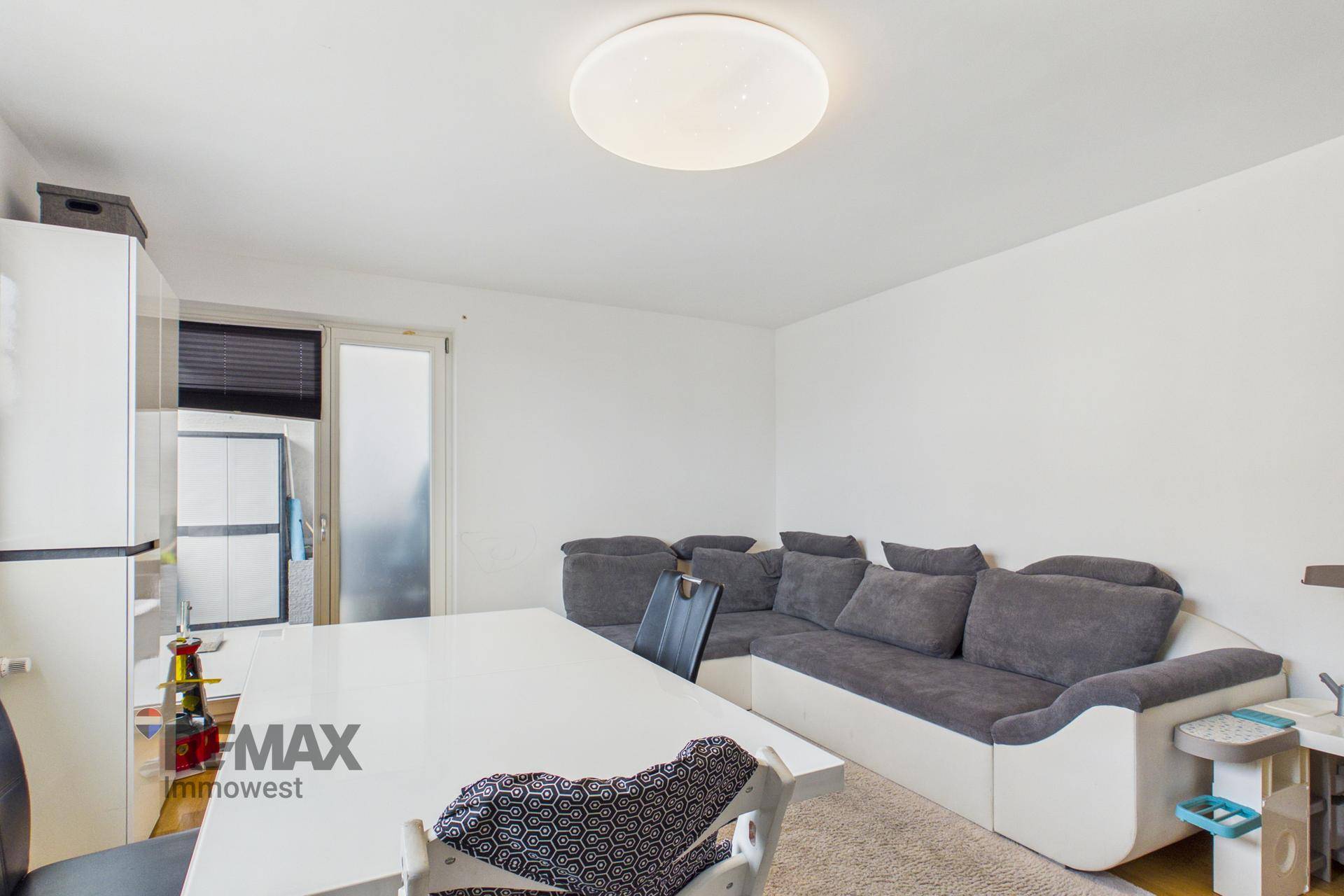 Gemütlicher Wohnbereich mit großem Sofa und Esstisch, ideal für gesellige Abende.