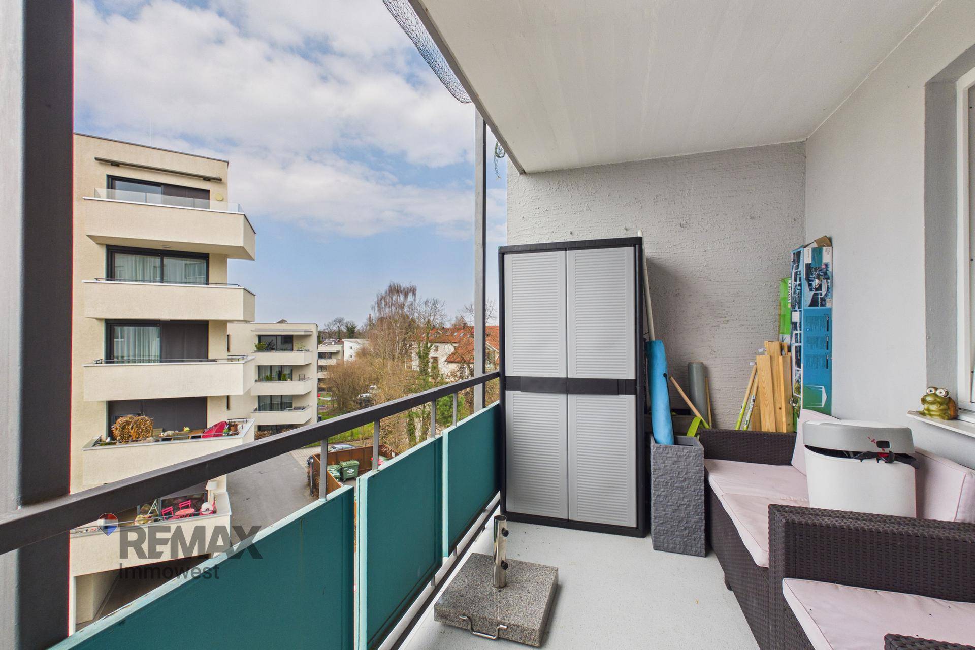 Möblierter Balkon mit Stauraum und Blick auf die umliegenden Gebäude und die Landschaft.