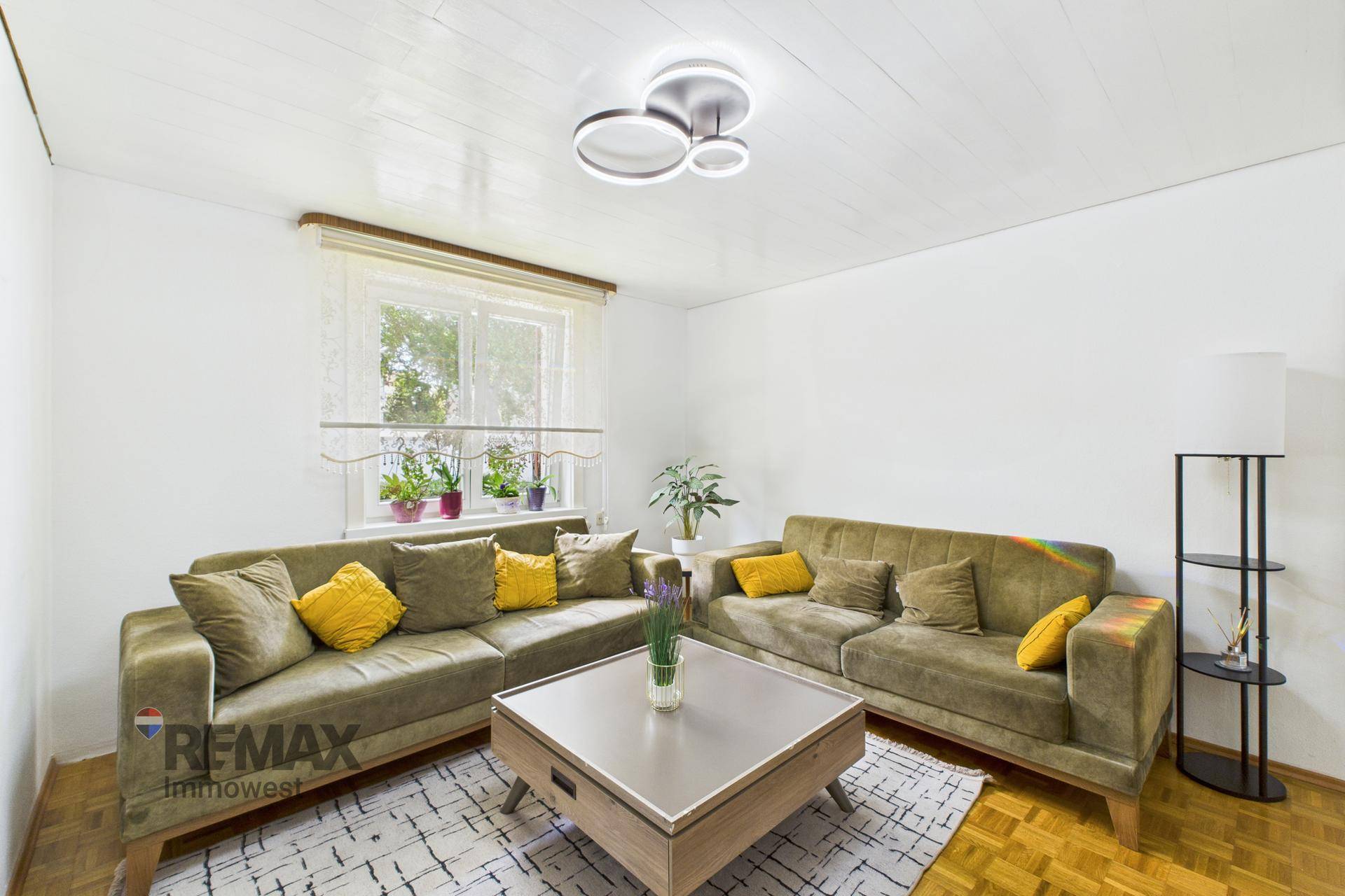 Helles Wohnzimmer mit zwei bequemen Sofas, Couchtisch und Fenster.