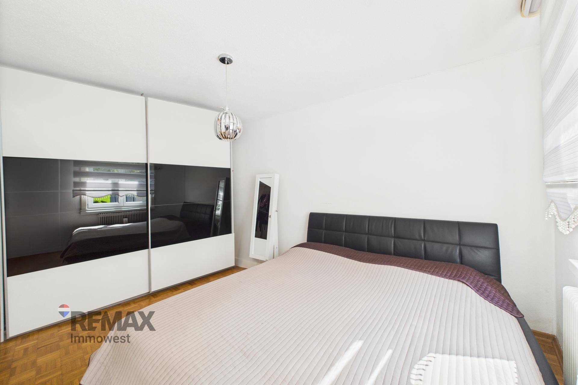 Schlafzimmer mit Doppelbett und großem Spiegelschrank, der den Raum erweitert.