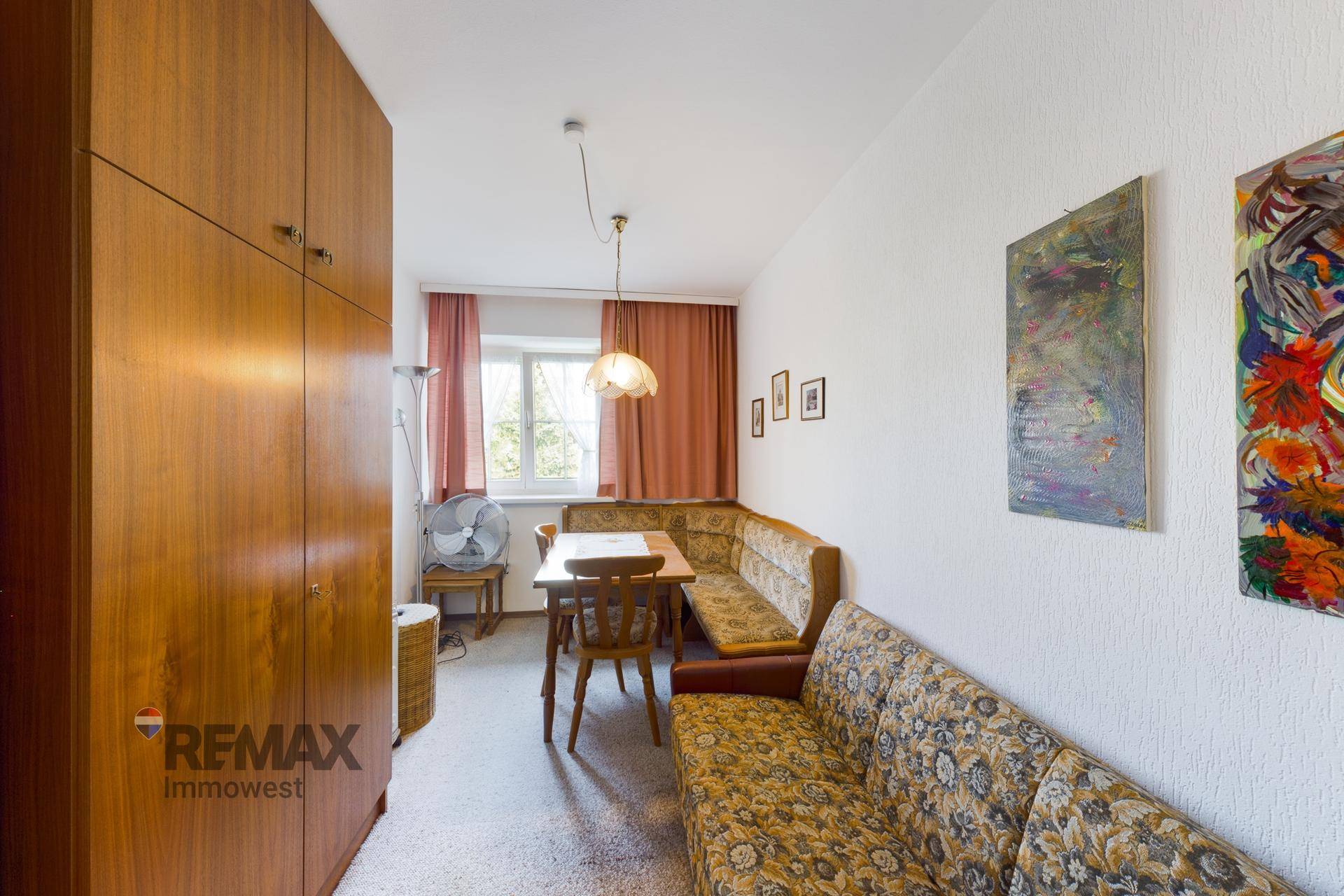 Kleiner Essbereich mit Eckbank, Holztisch und Teppichboden, umgeben von Holzmöbeln.