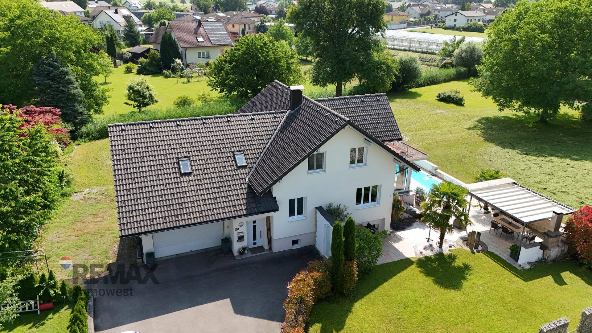 Vorderansicht des Hauses mit Doppelgarage, Einfahrt und gepflegtem Vorgarten.