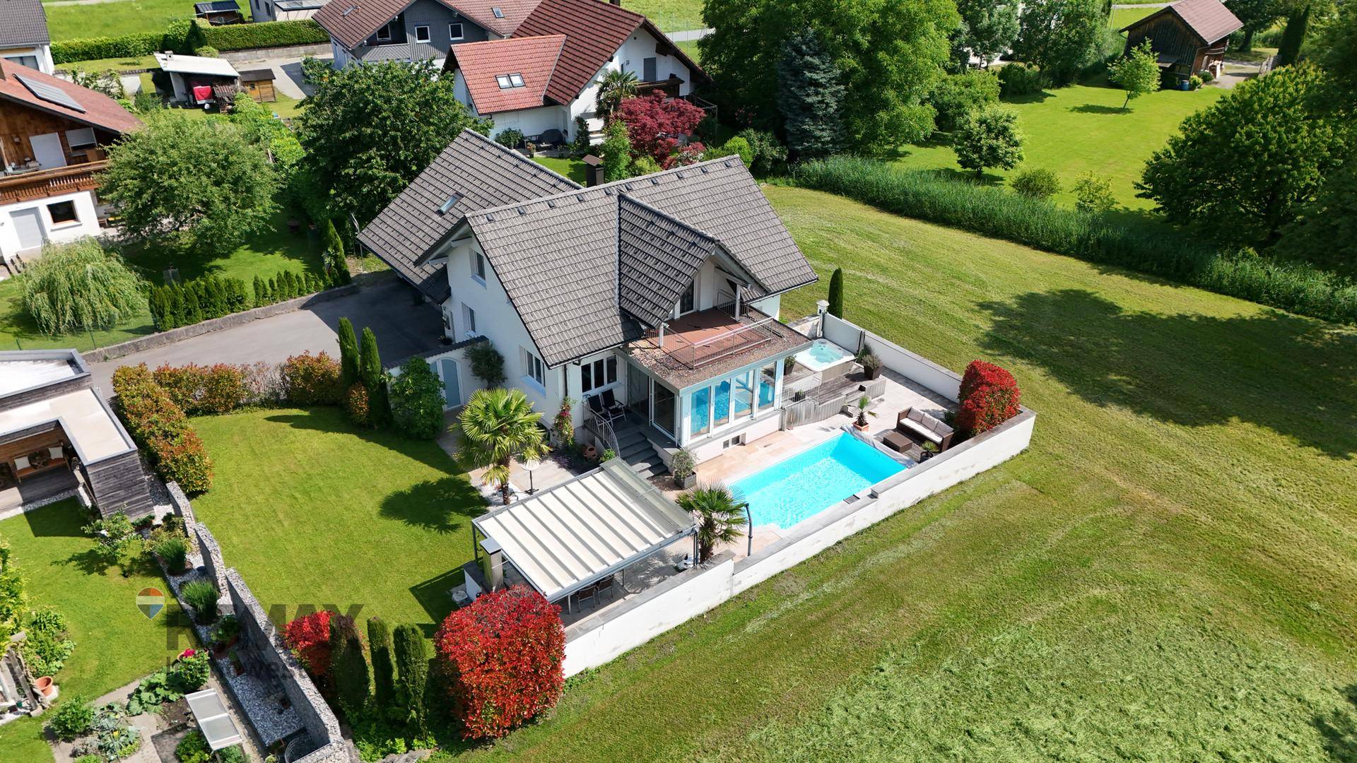 Vogelperspektive des Anwesens mit großem Garten, Poolbereich und angrenzenden Feldern.