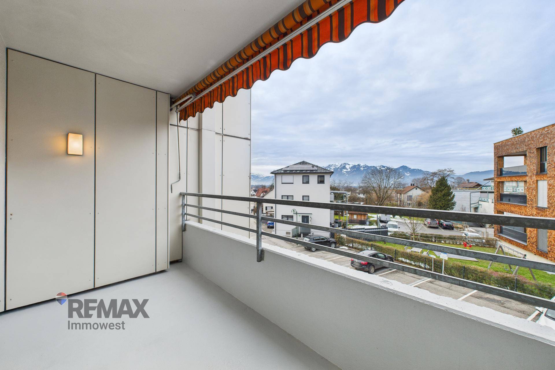 Geräumiger Balkon mit Markise und weitem Blick auf die umliegende Berglandschaft.