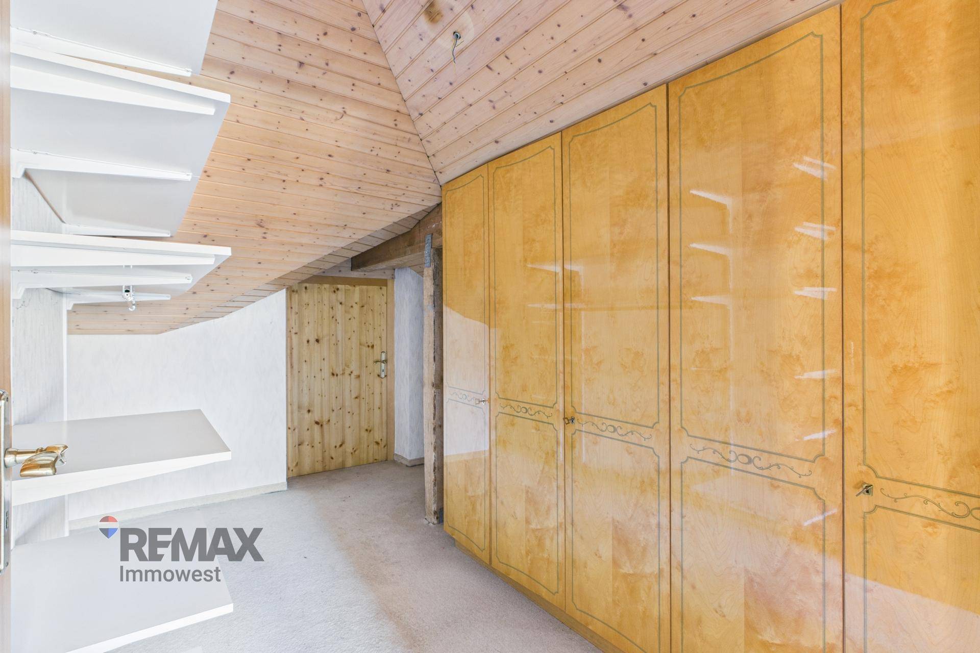 Dachgeschossflur mit praktischen Einbauschränken und Holzdecke für zusätzlichen Stauraum.