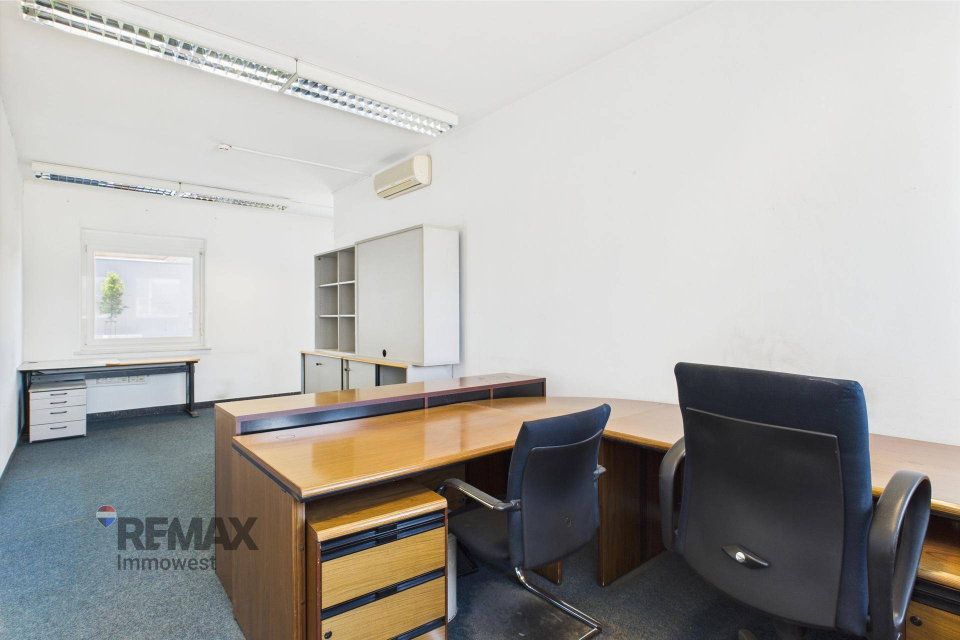 Büro mit zwei Arbeitsplätzen, Schreibtischen und Bürostühlen, ausgestattet mit Stauraum.