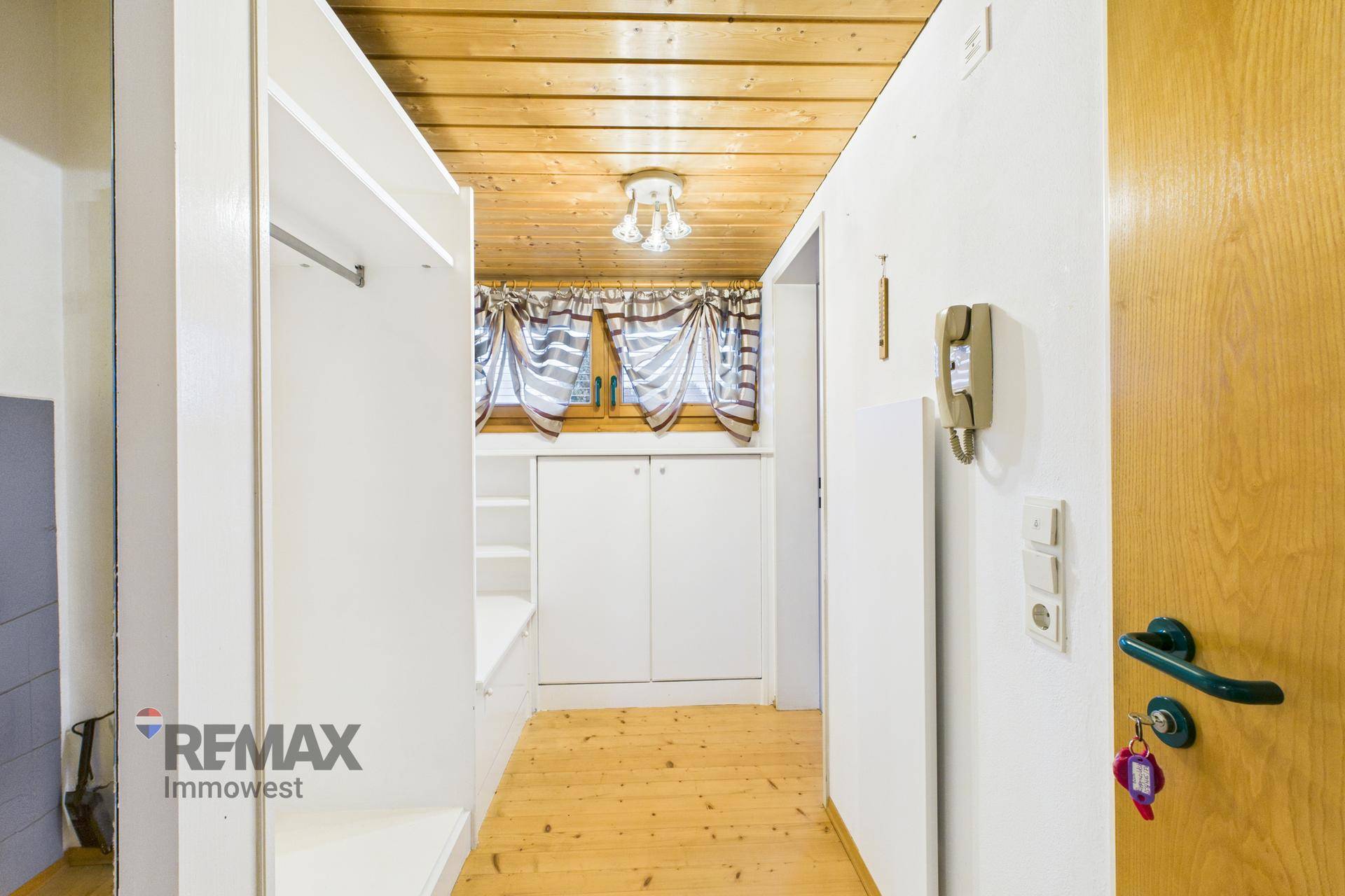Heller Flur mit Einbauschrank und Holzboden, der zu den weiteren Räumen führt.