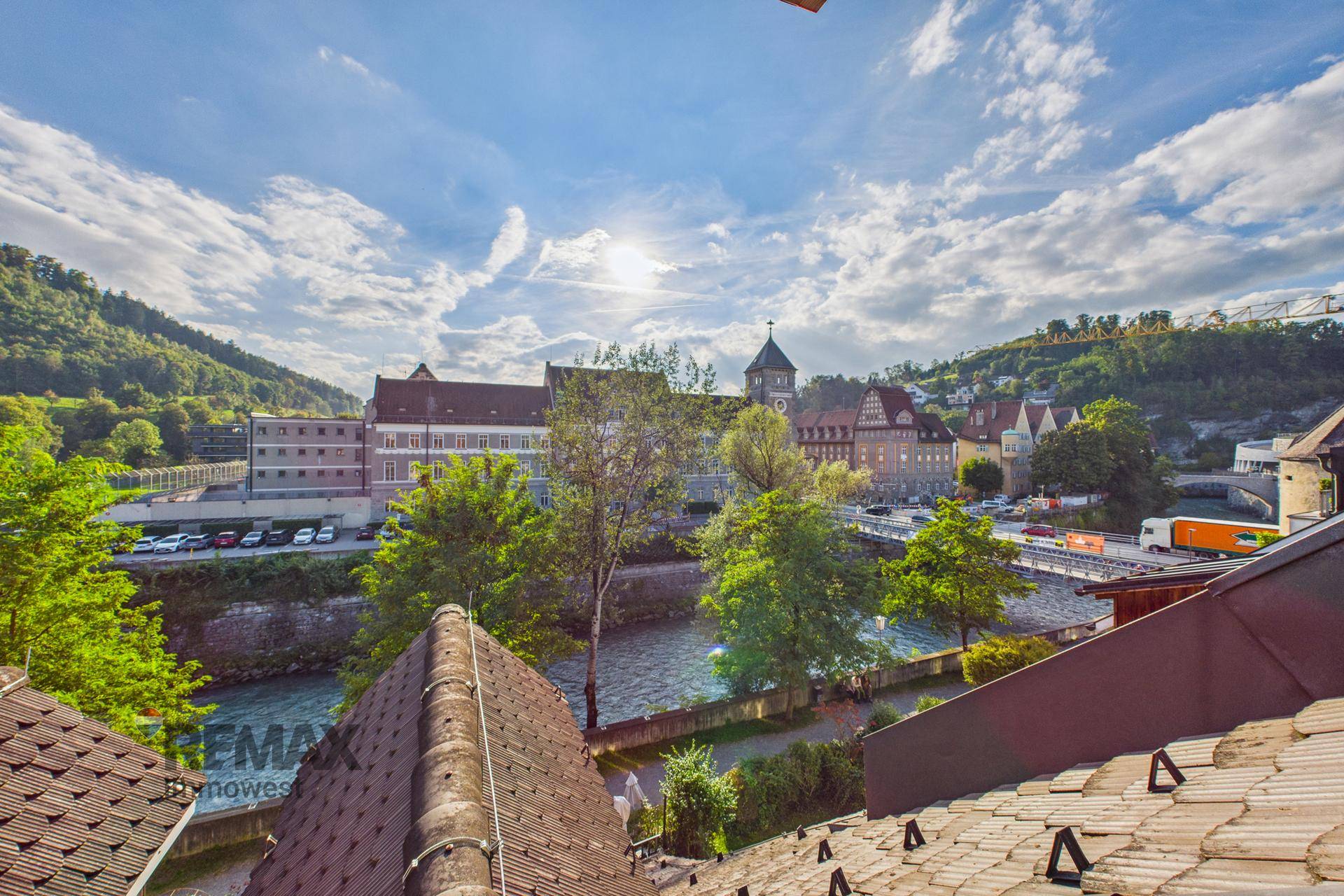 Panoramablick über die Stadt mit Fluss, historischen Gebäuden und grünen Hügeln.