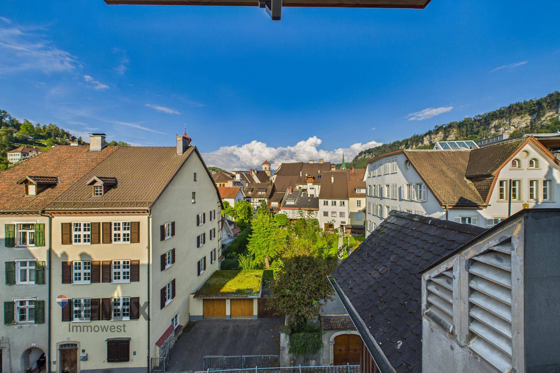 Weitblick über die Dächer der Altstadt mit traditionellen Gebäuden und viel Grün.