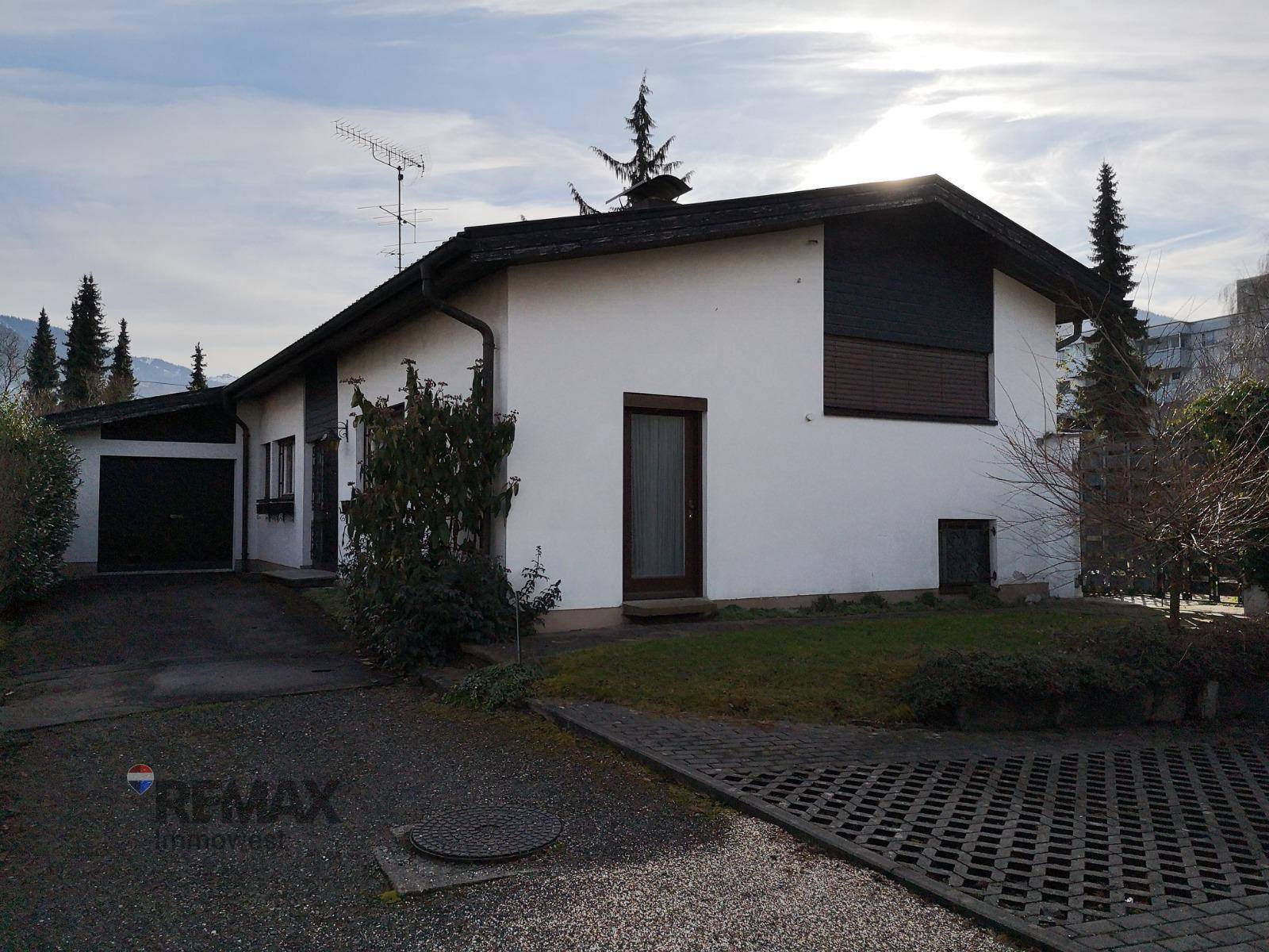 Vorderansicht des Einfamilienhauses mit Garage und gepflasterter Einfahrt im Winter.