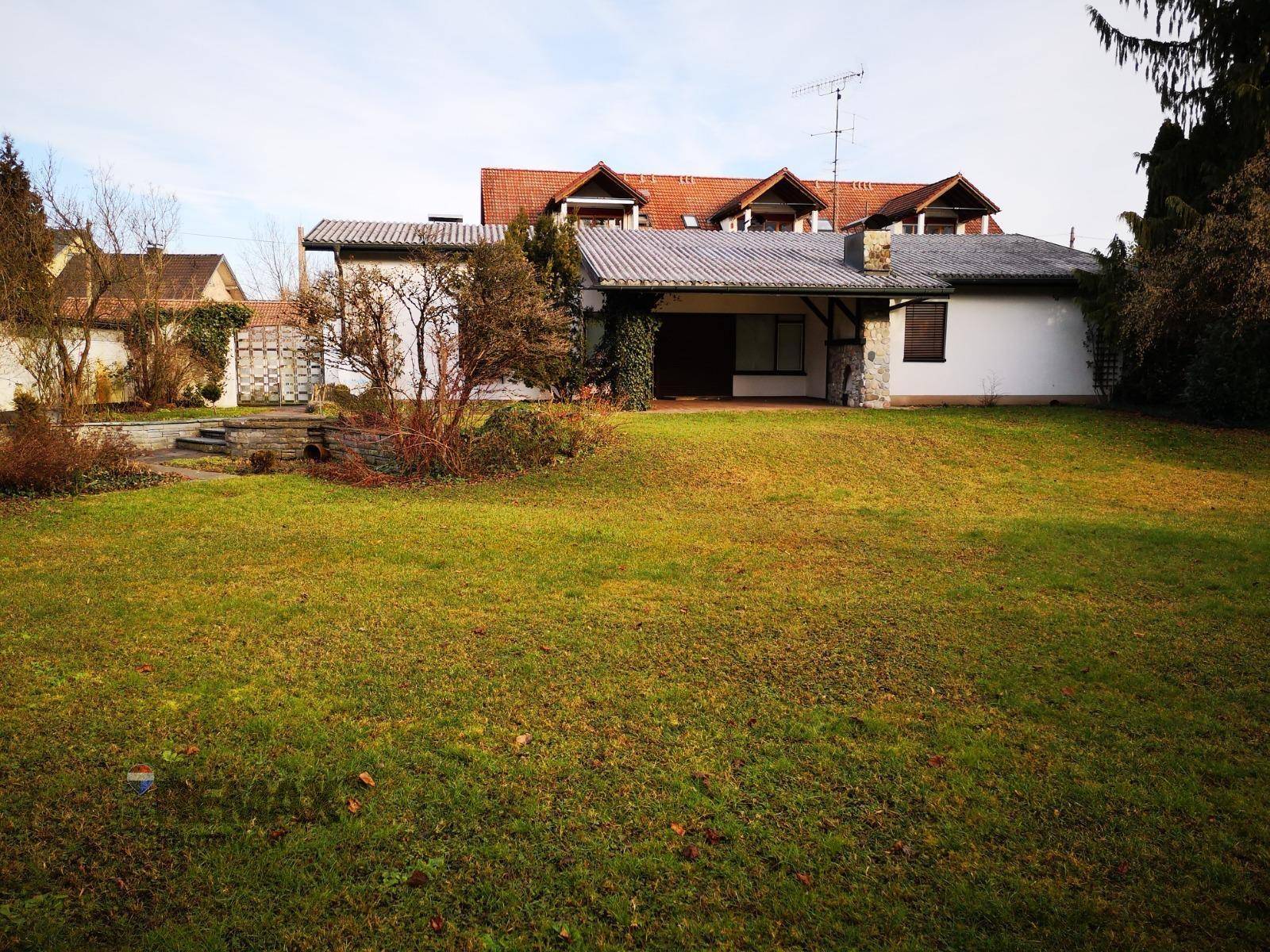 Weitläufiger Garten mit Rasenfläche und dem Haus im Hintergrund.