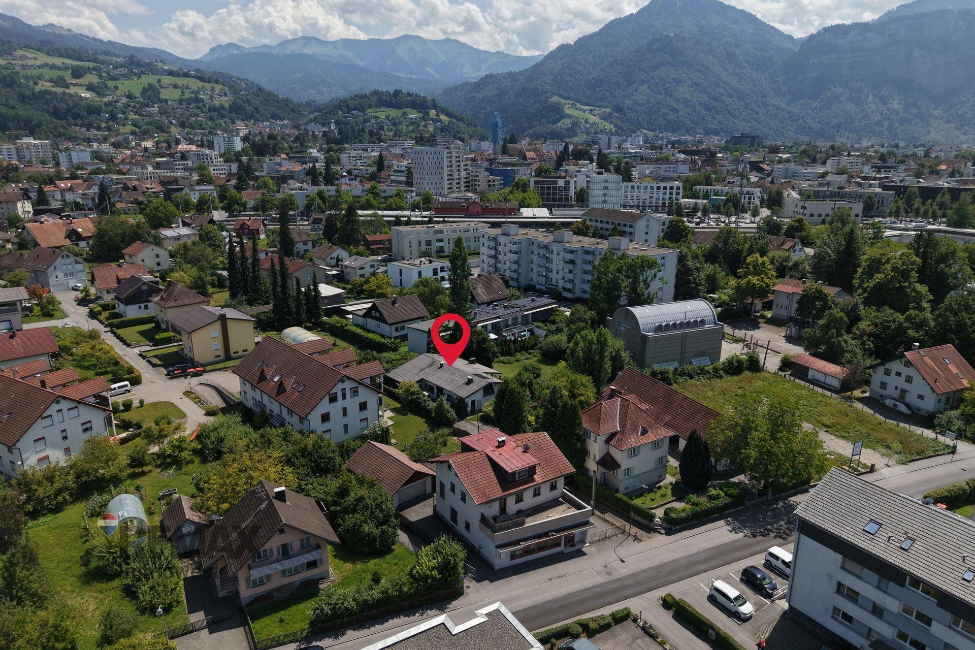 Weitläufige Luftaufnahme der Immobilie mit Stadt- und Bergblick im Hintergrund.