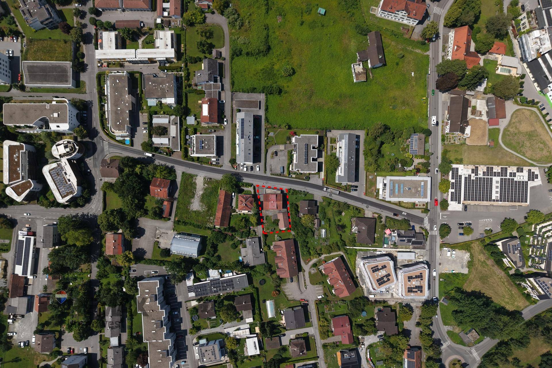 Weitläufige Luftaufnahme einer Wohnsiedlung mit viel Grün und Straßennetz.
