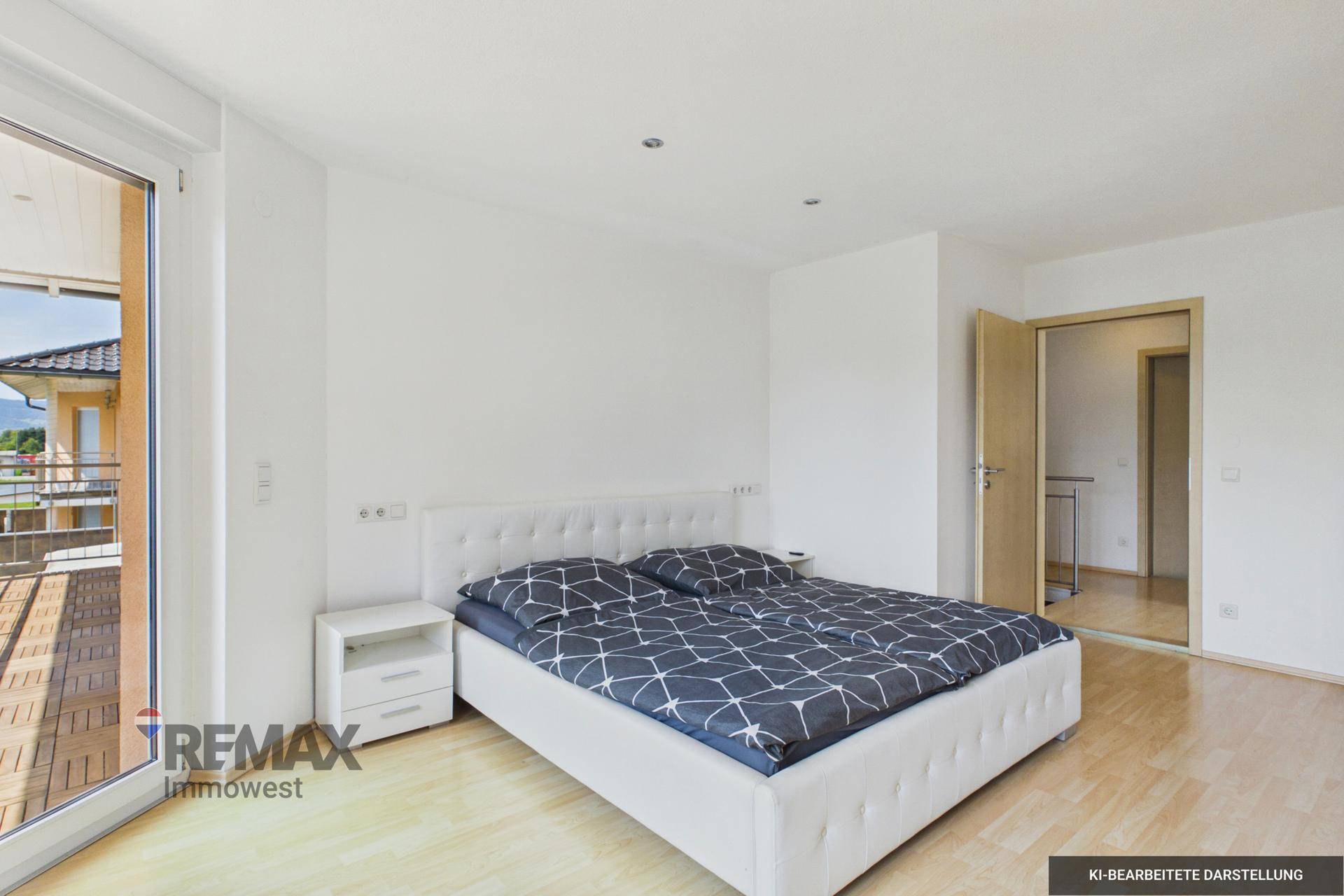 Schlafzimmer mit Doppelbett, Holzboden und Zugang zu einem Balkon mit Bergblick.