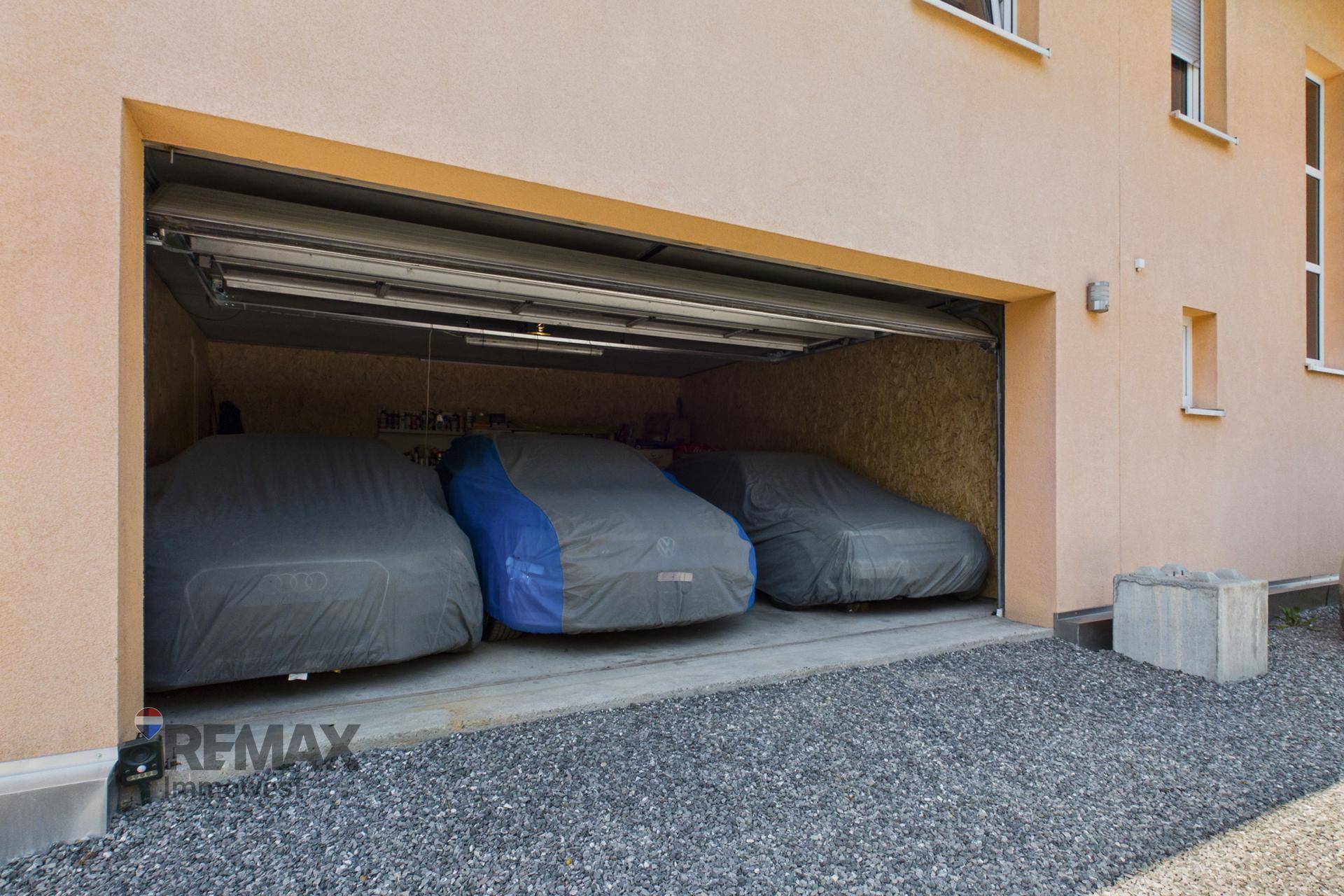 Geräumige Doppelgarage mit Platz für mehrere Fahrzeuge und automatischem Tor.