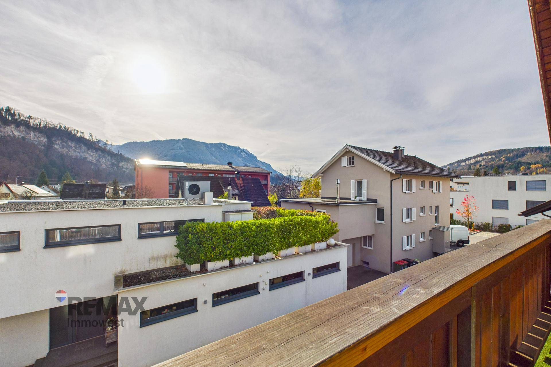 Panoramablick vom Balkon auf die Berge und die benachbarten Häuser.