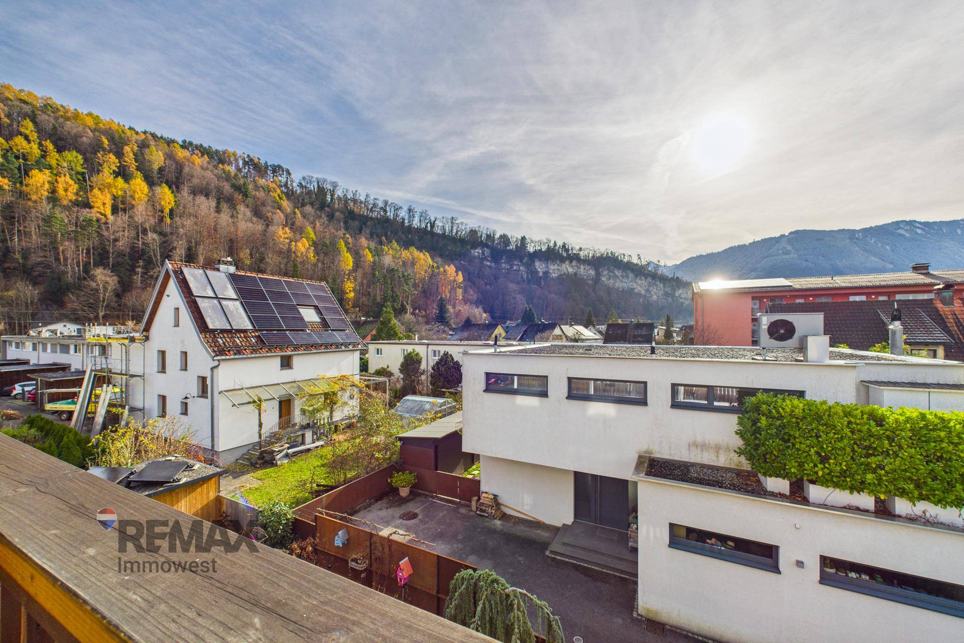 Weitläufiger Blick vom Balkon auf die umliegende Berglandschaft und andere Gebäude.
