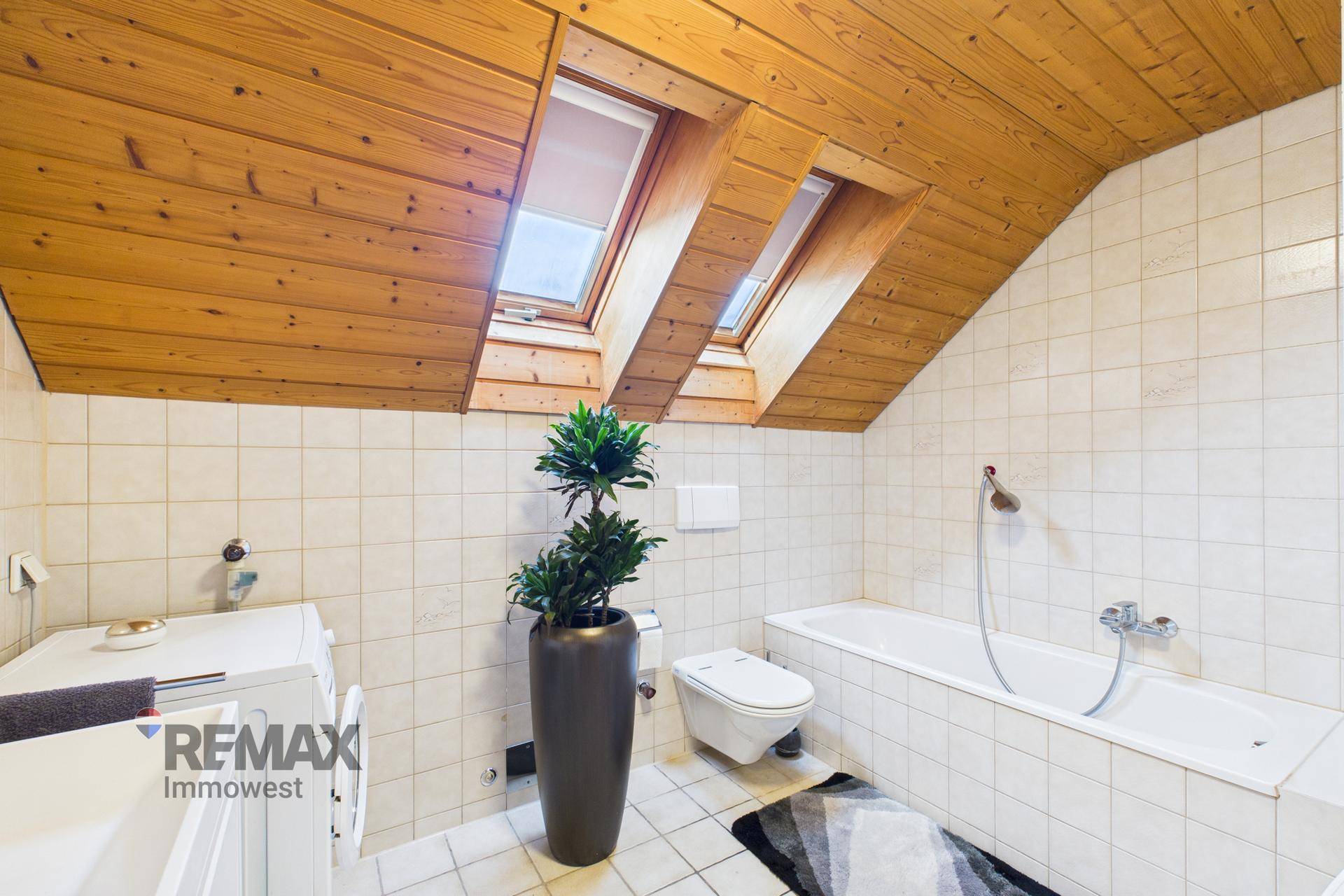 Helles Badezimmer im Dachgeschoss mit Badewanne, WC und Dachfenstern.