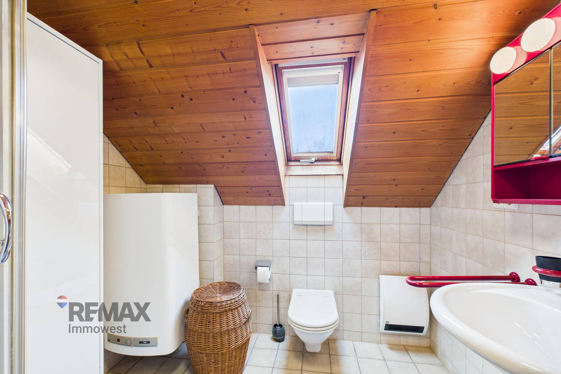 Badezimmer im Dachgeschoss mit Dusche, WC, Waschbecken und Dachfenster.