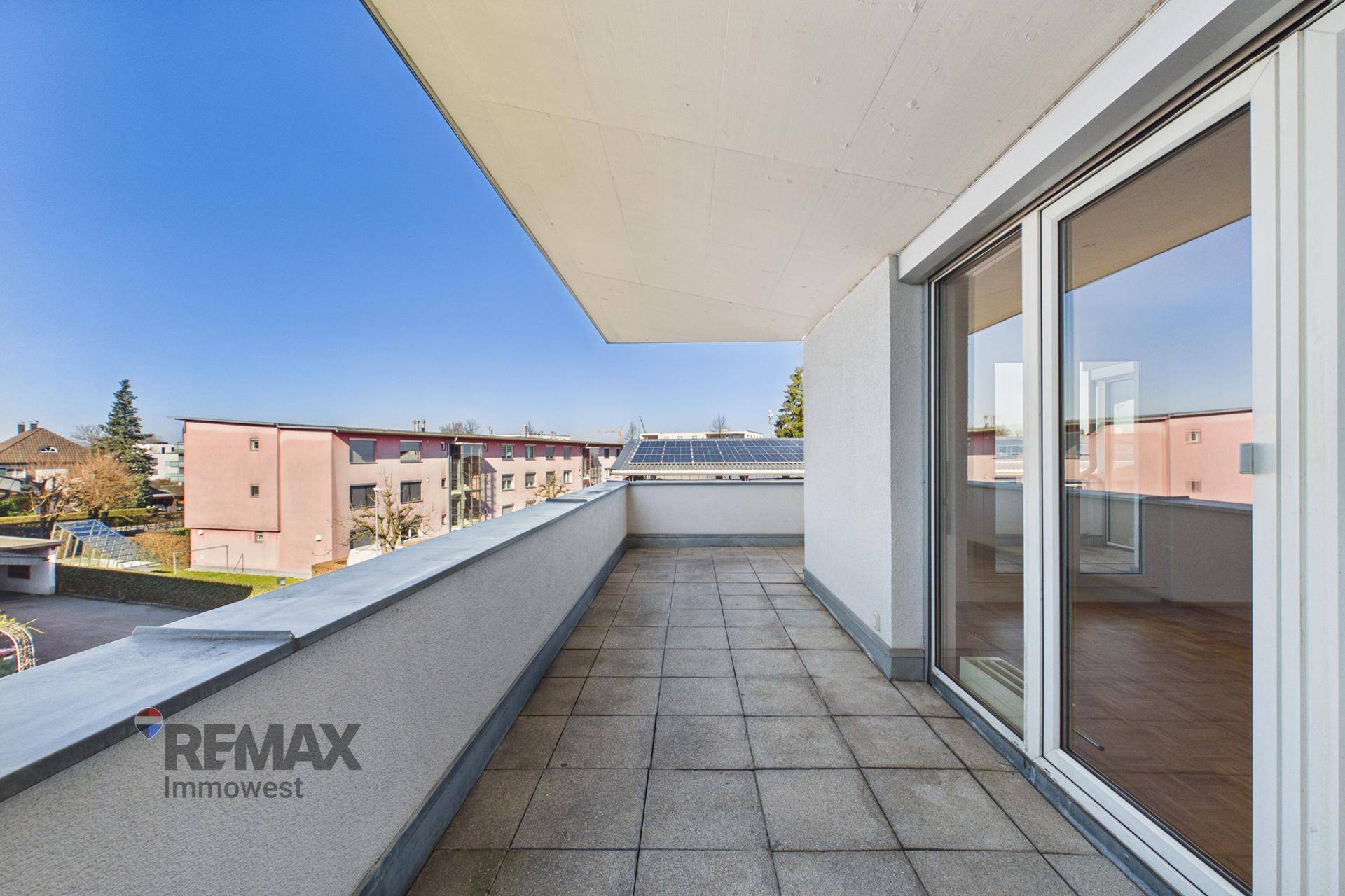 Geräumiger Balkon mit Fliesenboden und weitem Blick über die Wohngegend.