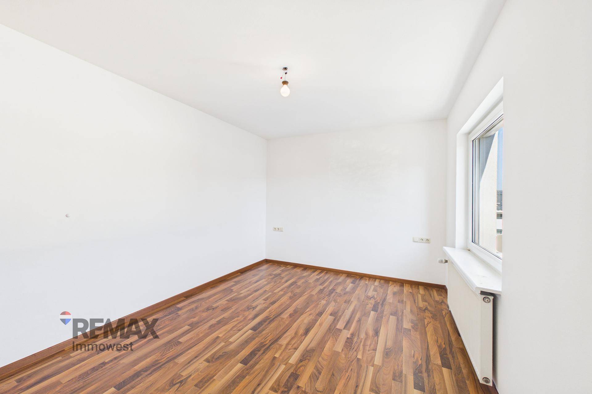 Unmöbliertes Schlafzimmer mit Laminatboden und weißen Wänden, ideal für individuelle Einrichtung.