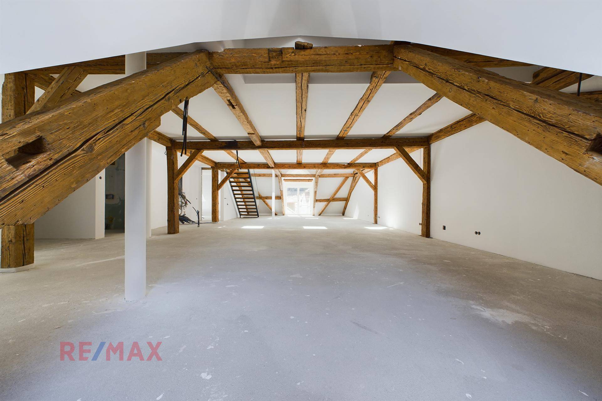 Weitläufiger Dachboden mit beeindruckenden Holzbalken und viel Tageslicht, ideal für ein Loft-Wohnkonzept.