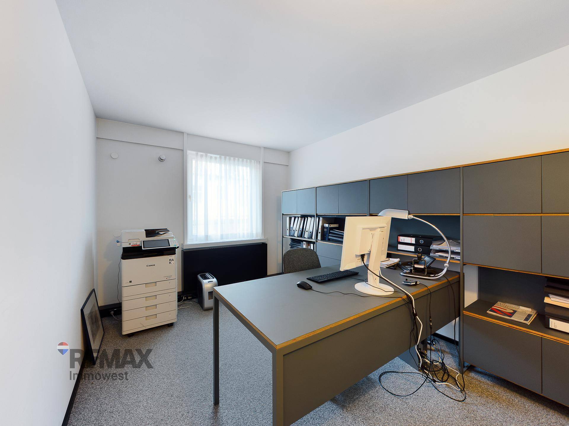 Funktionales Büro mit Schreibtisch, Bürostuhl und integrierten Schränken für Stauraum.