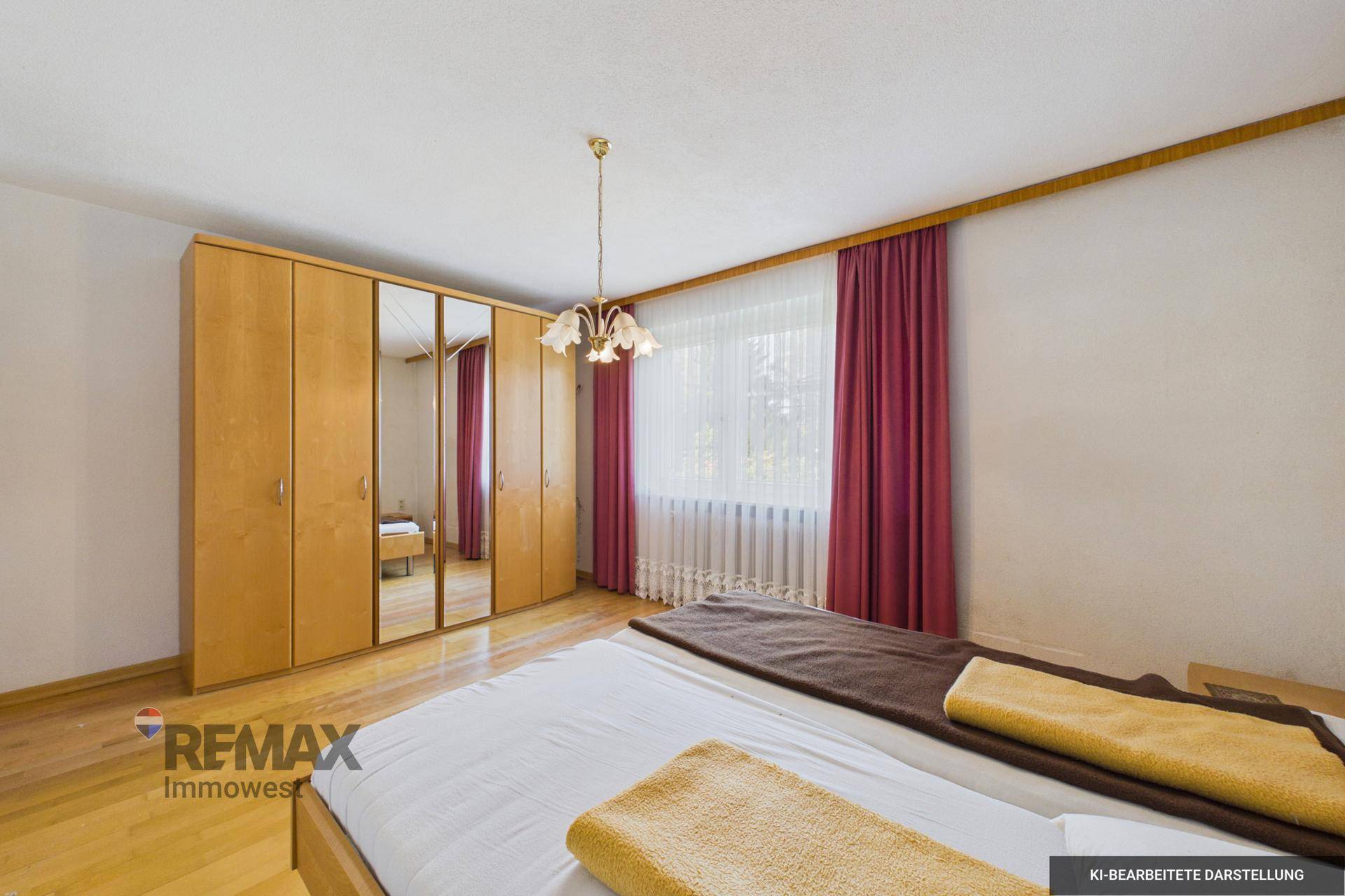 Schlafzimmer mit großem Holzschrank, Spiegeltüren und Holzparkett, hell und geräumig.