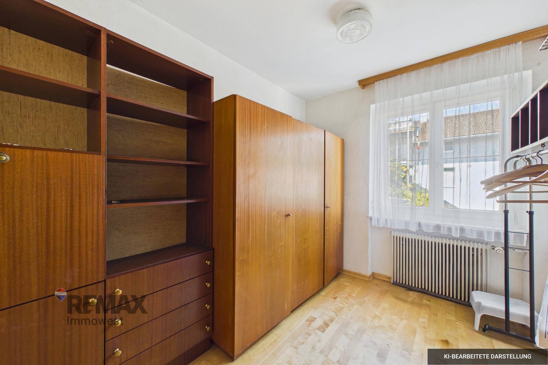 Zimmer mit Holzregalen, Kleiderschrank und Holzparkett, ideal als Gäste- oder Arbeitszimmer.
