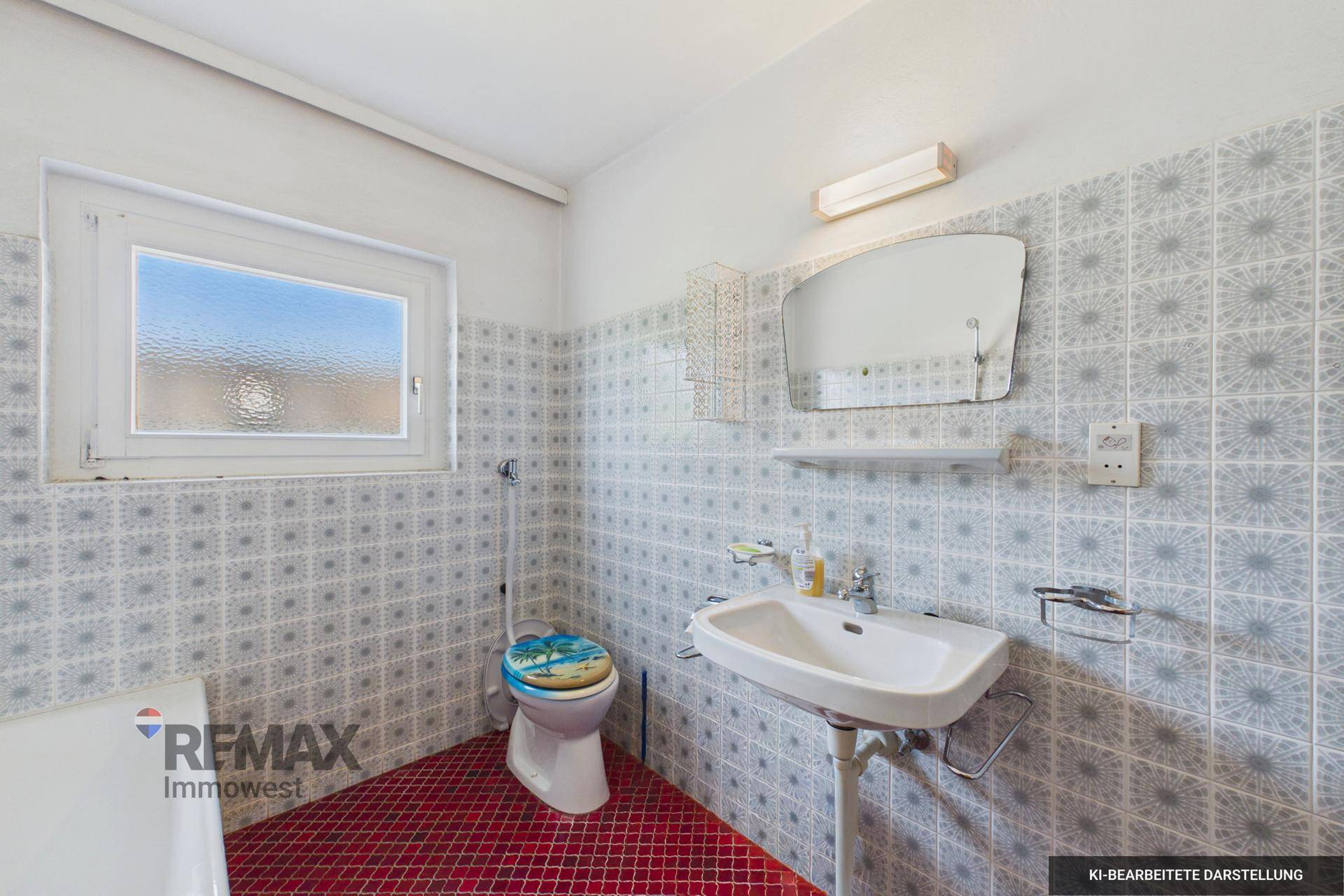 Badezimmer mit Waschbecken, WC und Spiegel, umgeben von gemusterten Fliesen und rotem Boden.