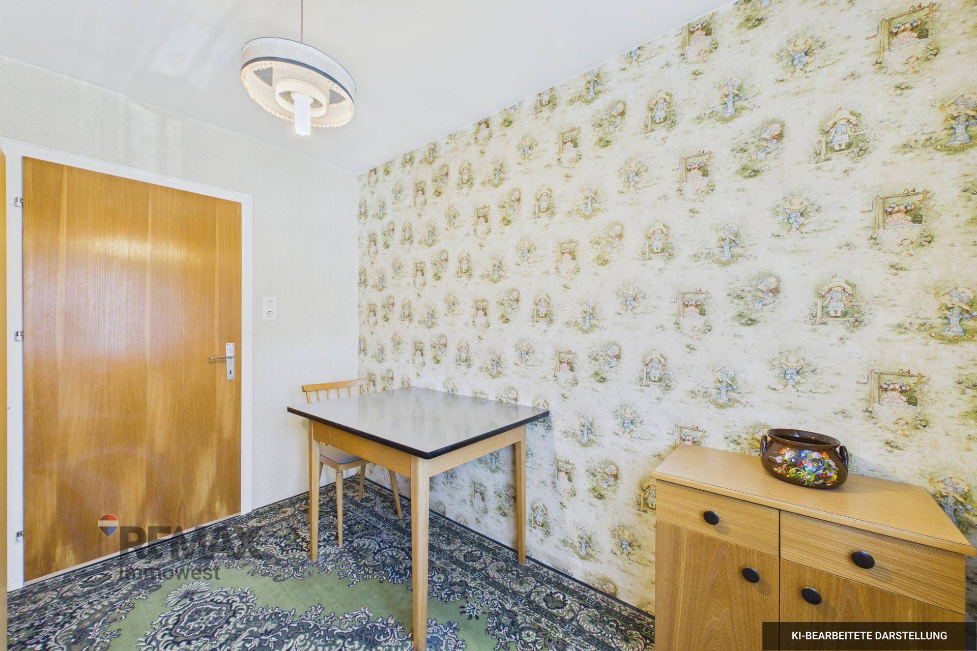 Weiterer Blick in das Zimmer mit gemusterter Tapete, kleinem Tisch und Holztür.