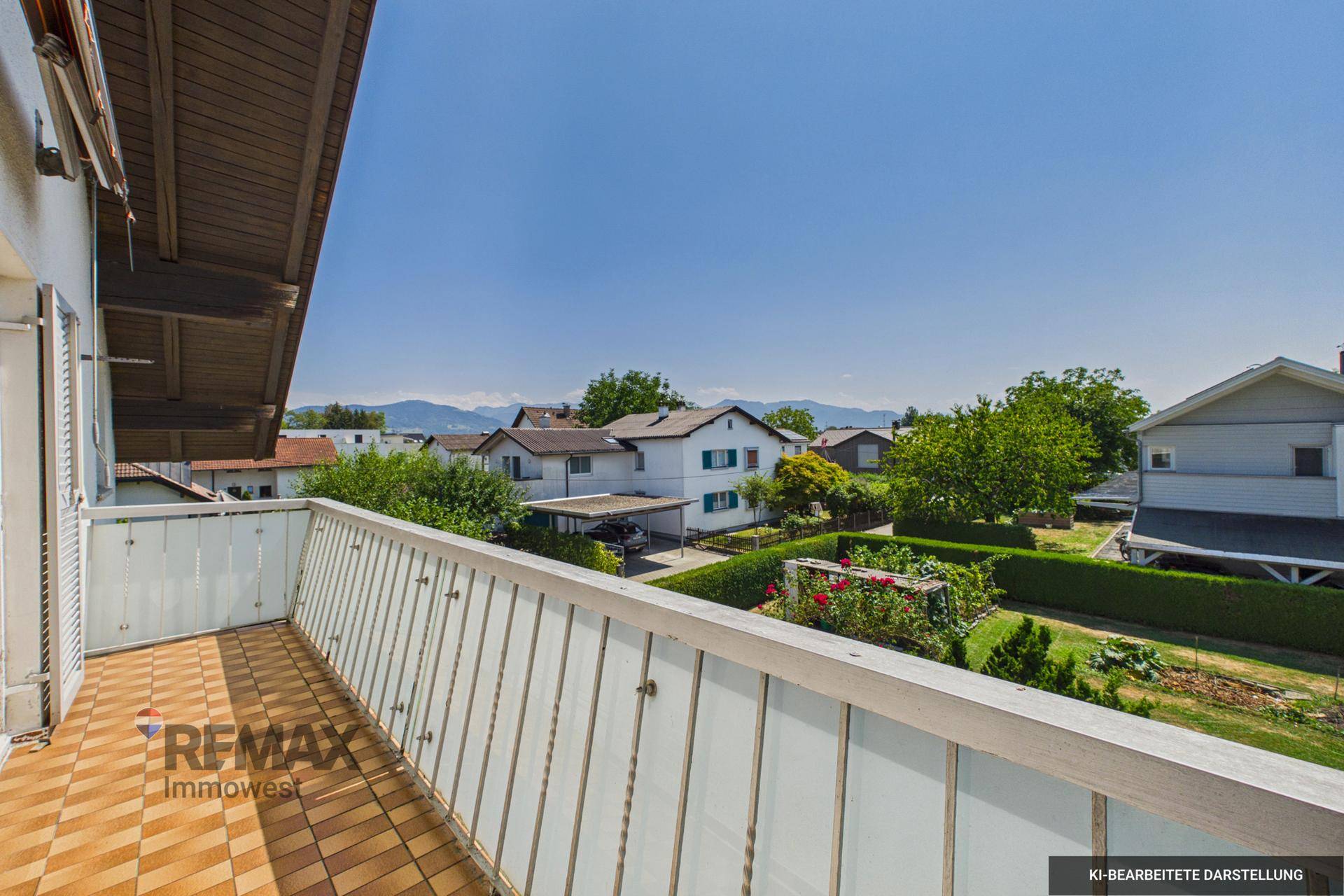 Balkon mit Fliesenboden und weitem Blick über die Nachbarschaft bis zu den Bergen.