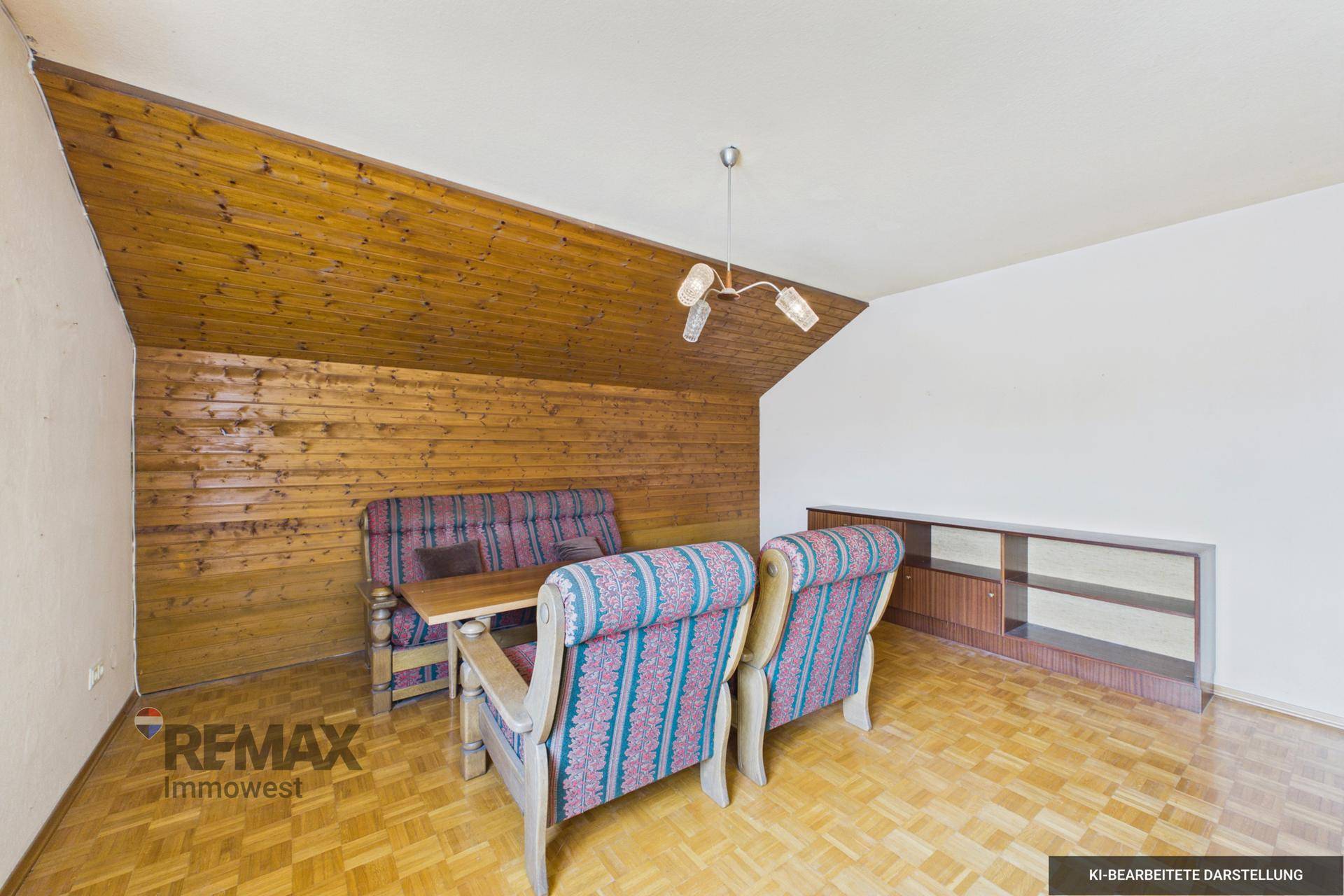 Gemütlicher Wohnbereich mit Holzvertäfelung an Wand und Decke sowie älteren Möbeln.
