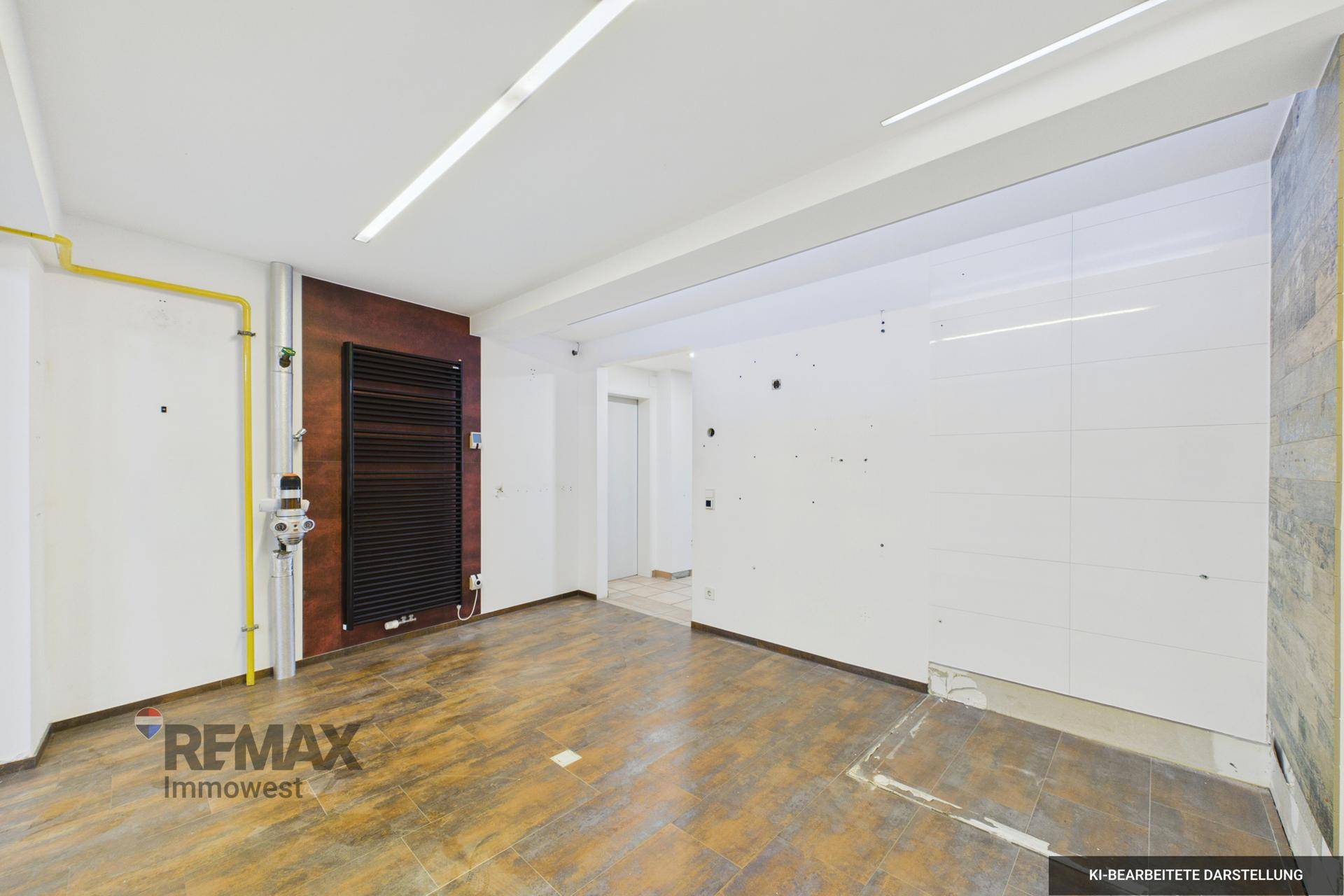 Unfertiger Raum mit Holzboden, Heizkörper und sichtbaren Installationen, bereit für den Ausbau.