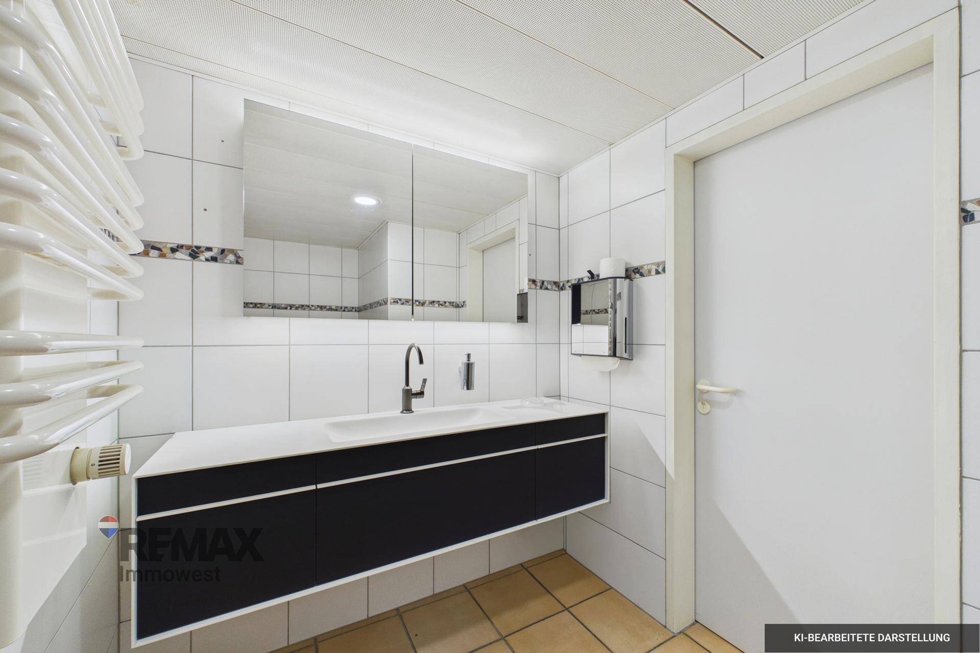 Modernes Badezimmer mit weißen Fliesen, schwarzem Waschtischunterschrank und Handtuchheizkörper.