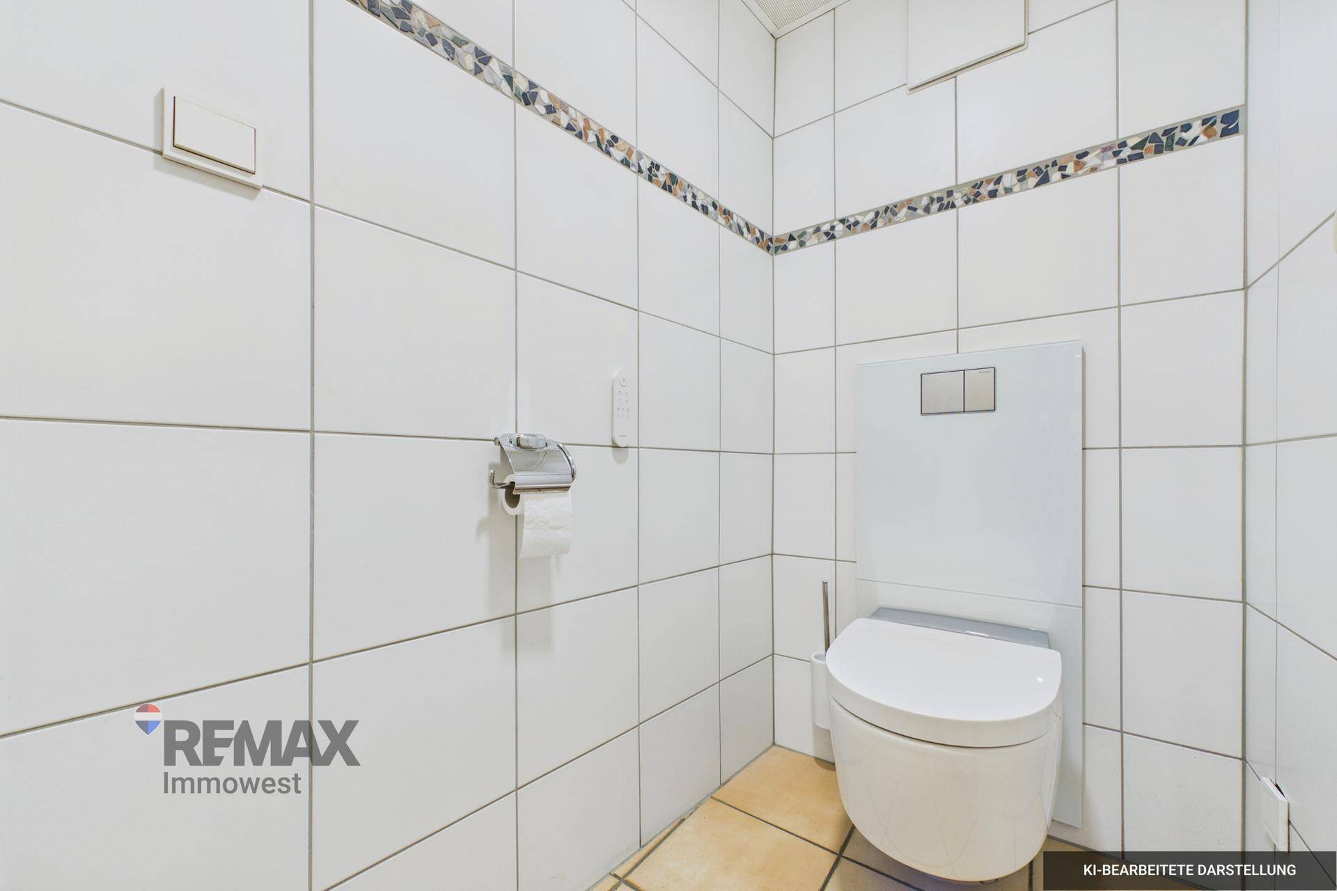 Geflieste Toilette mit wandhängendem WC und Mosaikbordüre, in einem modernen und sauberen Stil.