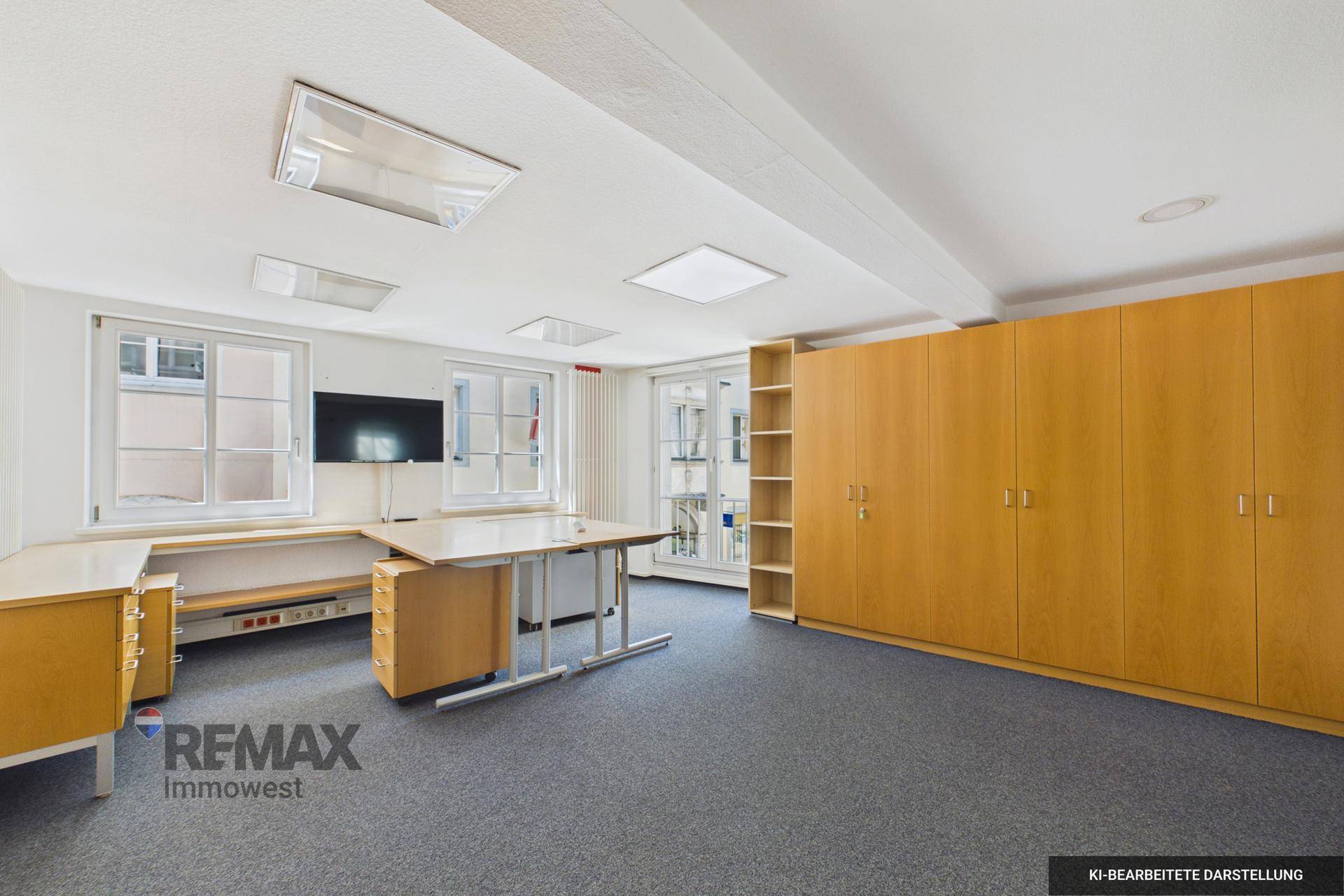 Helles Büro mit Teppichboden, großen Fenstern und integrierten Holzschränken, gut ausgestattet.