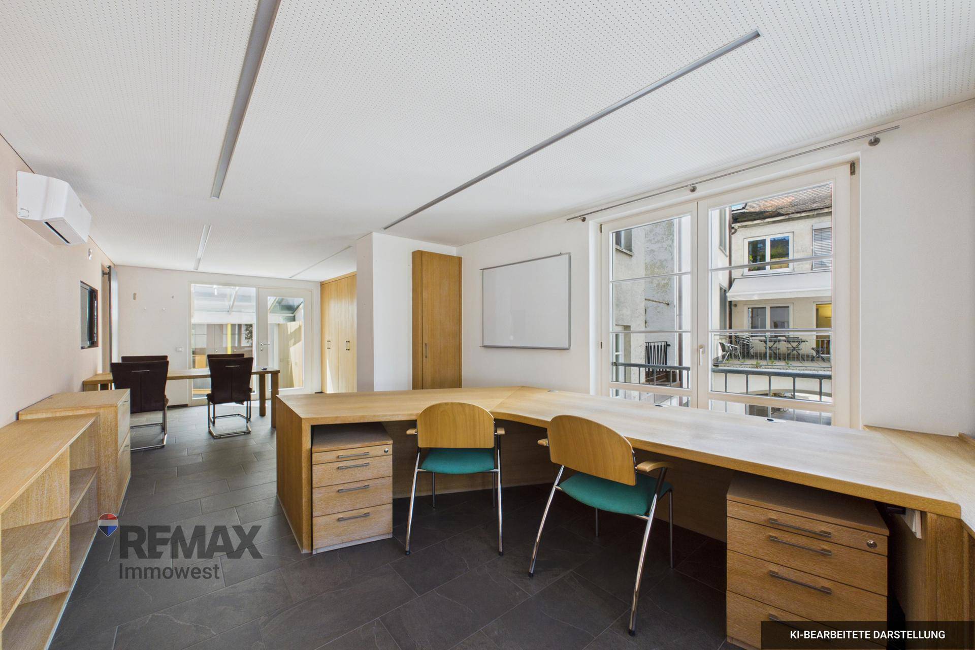 Helles Büro mit großen Fenstern, dunklem Fliesenboden und funktionalen Arbeitsplätzen.