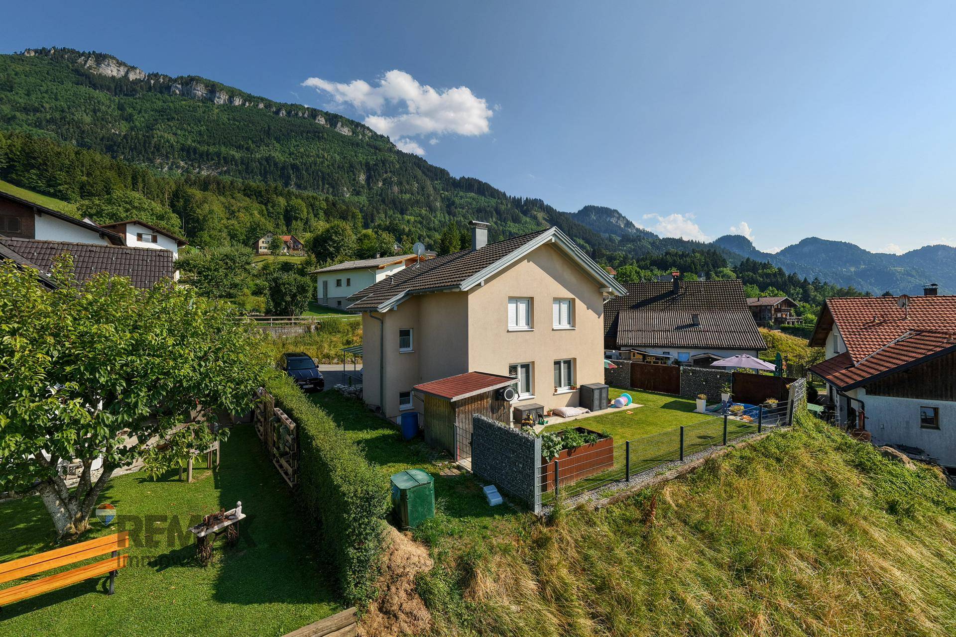 Einfamilienhaus in ländlicher Umgebung mit großem Garten und Bergblick.