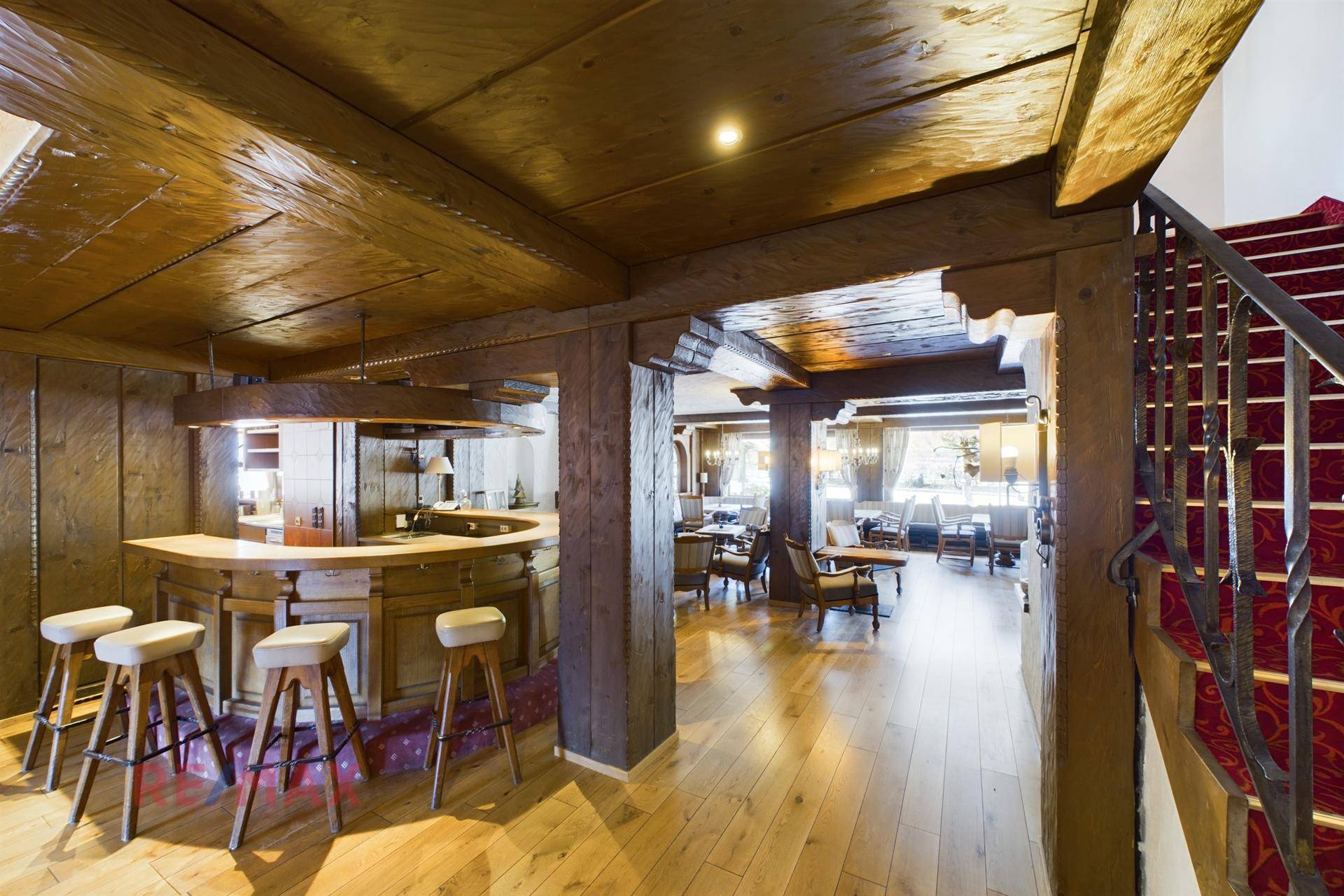 Rustikale Bar mit Holzelementen und einer Treppe, die zu weiteren Bereichen des Anwesens führt.